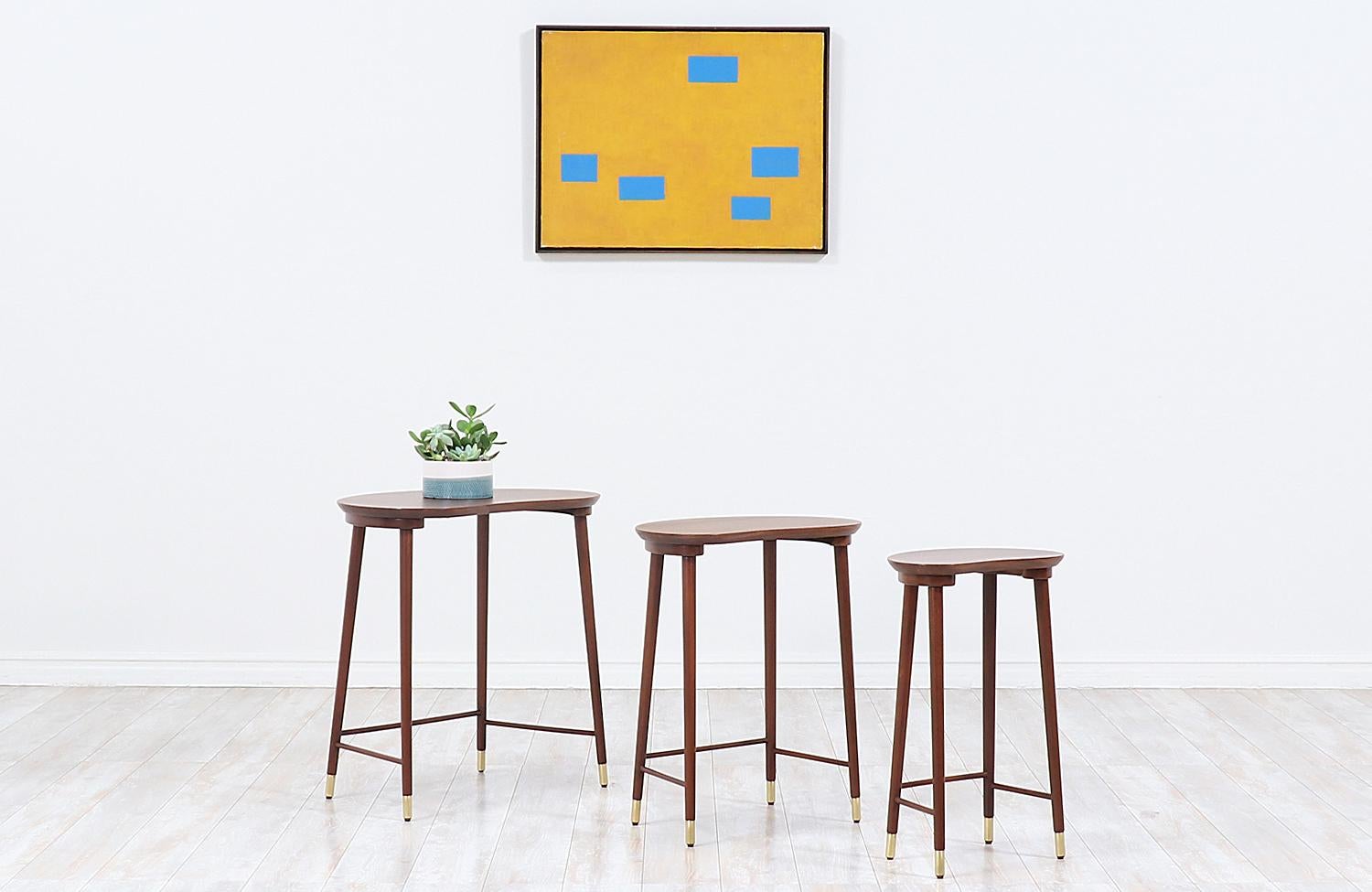 Versatile set of three nesting tables designed by Danish designer Edmund Jørgensen in collaboration with Danish company, Møbelfabriken Gorm, who operated in the city of Aarhus in the 1950s. Our tables feature kidney shape mahogany tabletops and
