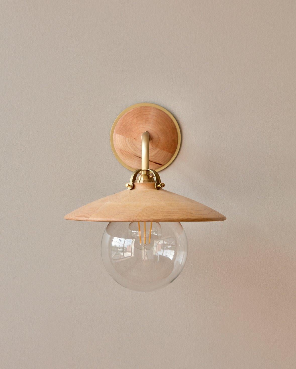 The Edmund sconce adopts the charismatic details from our beloved Edmund Pendant with its distinctive and charming shape. The hand-turned shade and oversized clear globe create a playful silhouette while delicate cut brass fittings and hardware are