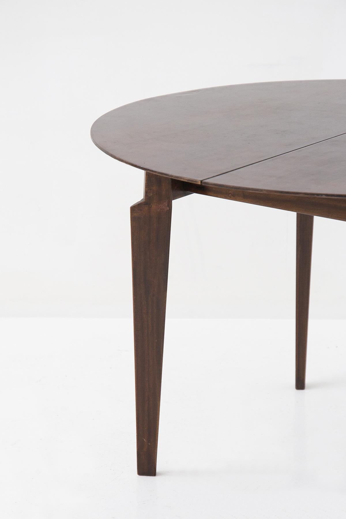 Beautiful 1950s round table of Italian manufacture Dassi designed by Edmundo Palutari.
The table is entirely made of a very dark brown wood, very elegant. There are 4 supporting legs of triangular shape, very distinctive and delicate. These legs