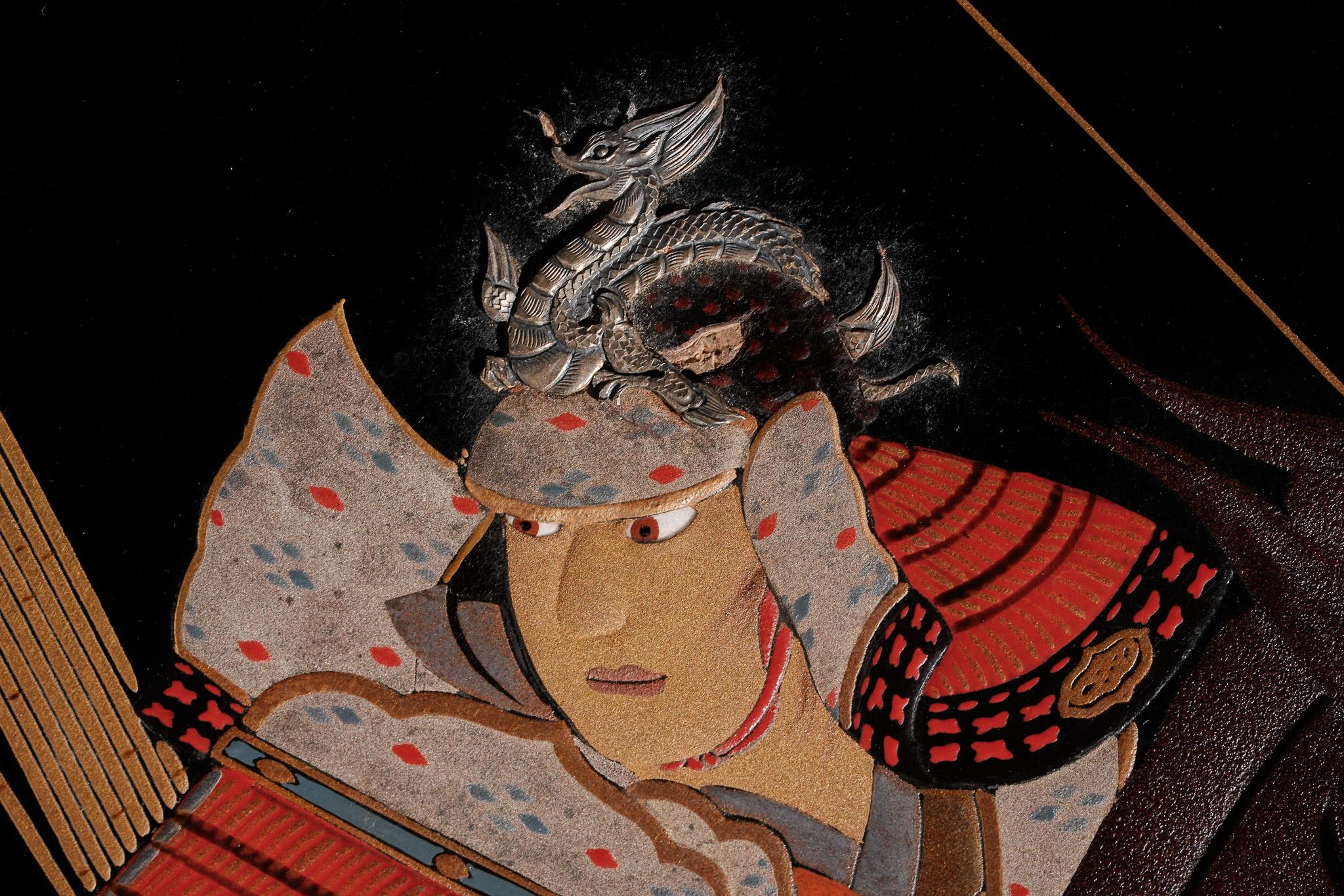 Dieses Makie Suzuribako aus der Edo-Periode zeigt den legendären General Minamoto no Yoshiie aus der Heian-Periode, weithin bekannt als Yawata Tarō, der mit gespanntem Bogen zu Pferd angreift. Yoshiie, der als idealer Krieger gefeiert wird und unter