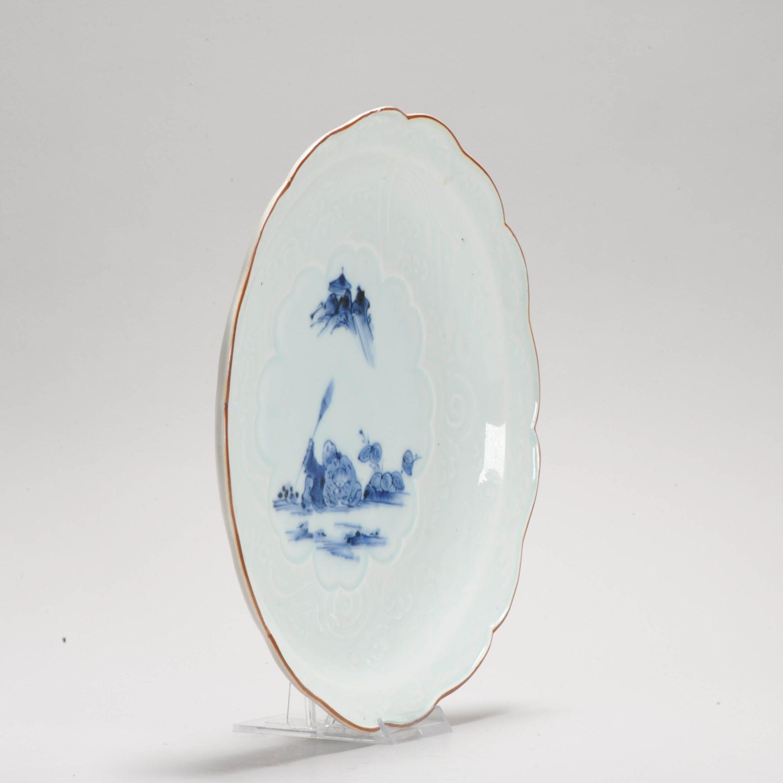 Edo Period Arita Japanese Porcelain Dish Arita Kanzan & Jittoku, ca 1700-1730.

Oliver Impey - Porcelain for Palaces

403. Plate
Blue-and-white, Arita
c. 1700-30
Reitlinger gift 1978.1926
Bight-foliated plate. Narrow, flanged border and brown-edged