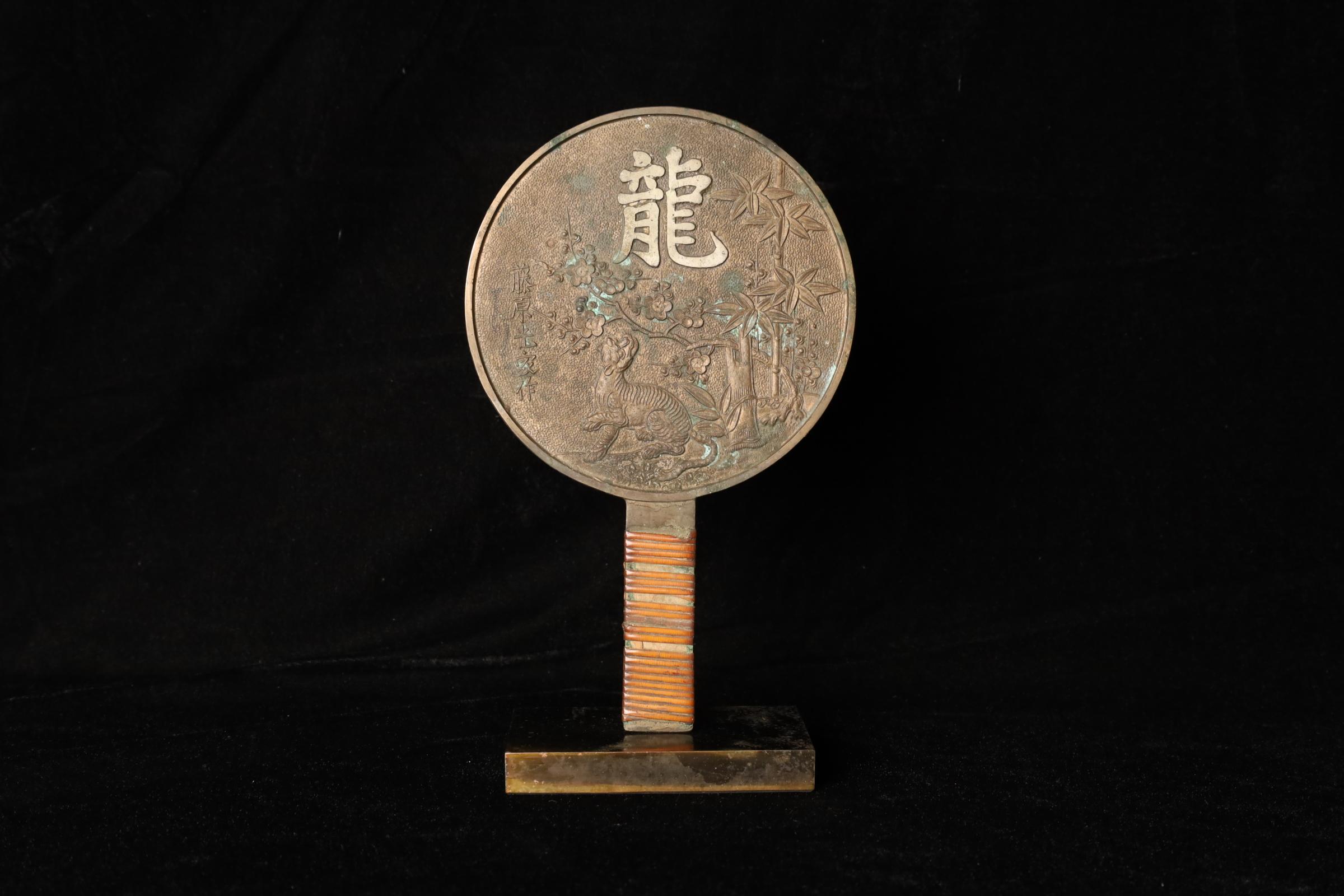 Ein fein gegossener Bronzespiegel aus der Edo-Periode, der ein außergewöhnlich seltenes Motiv zeigt: einen kräftigen Tiger vor eleganten Pflaumenblüten. Die kontrastreiche Bildsprache verkörpert Stärke und Widerstandsfähigkeit gepaart mit