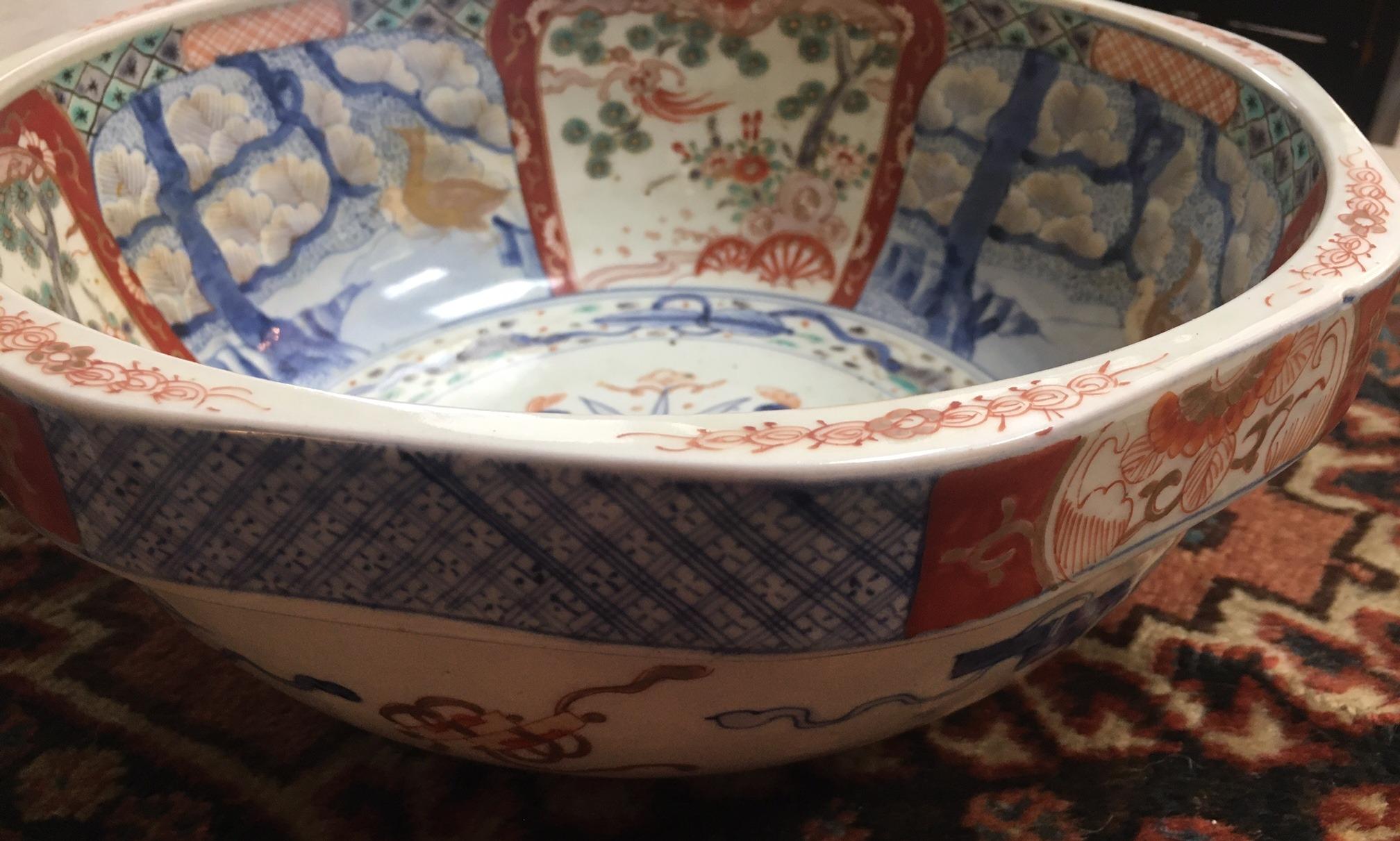 Ce beau bol japonais Imari est rare pour deux raisons. D'abord en raison des couleurs pâles et ensuite en raison de la forme octogonale inhabituelle avec huit vignettes qui entourent un grand bouclier au centre. Des motifs fantaisistes de fleurs,