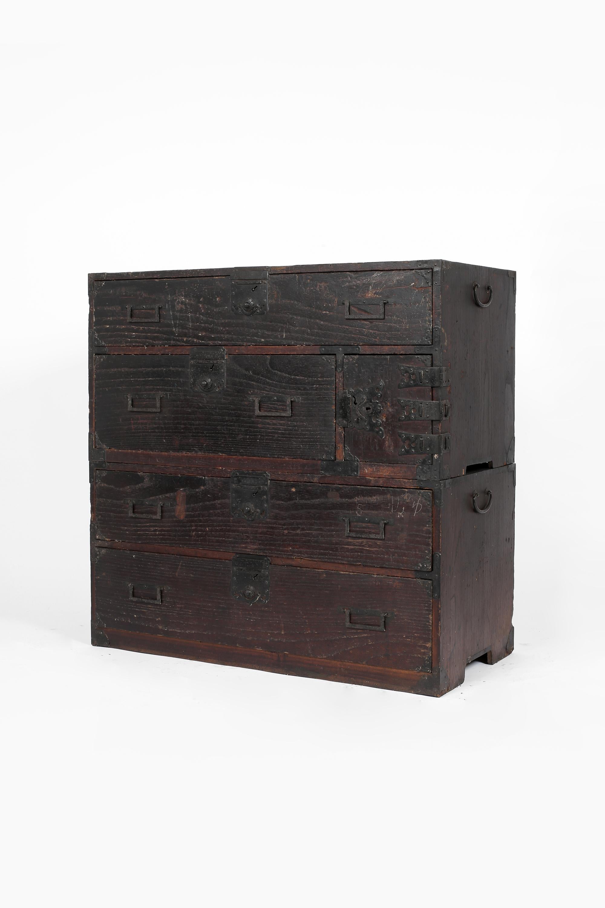 An Edo period Tansu chest, constructed from dark heavily patinated cedar with decorative forged iron hardware. The right hand door opens to reveal an internal drawer and hidden secret compartment. Japanese, c. 1840.
