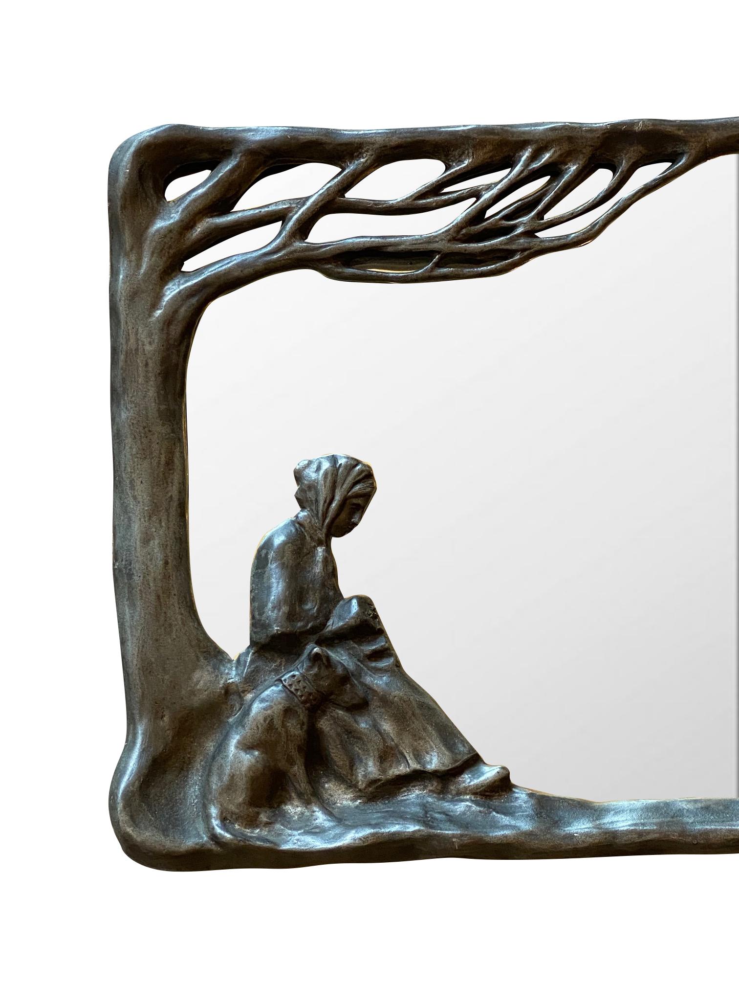Art Nouveau wall hung mirror circa 1900 by renowned French jewelry artist Edouard Aimé Arnould. Cast patinated framework depicting a woman and her canine overlooking a grazing herd of sheep. Stamped artist's name appears on top side edge along with