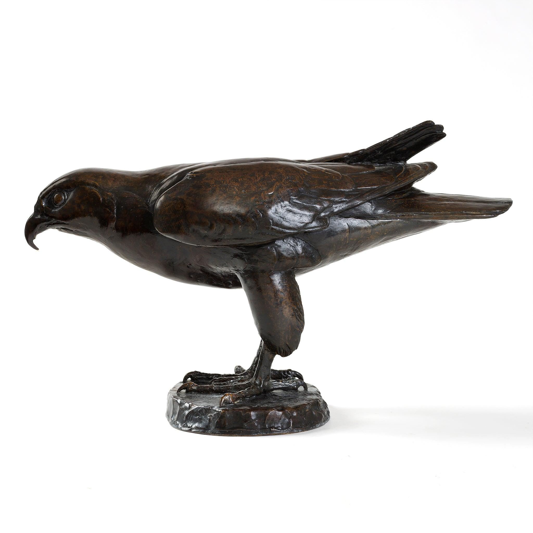 This naturalistic bronze sculpture of a perching falcon was created in 1956 by the Swiss-French animalier Édouard Sandoz. The bird of prey is depicted in a dynamic pose at the edge of a rocky perch, perhaps on the verge of opening its wings, its