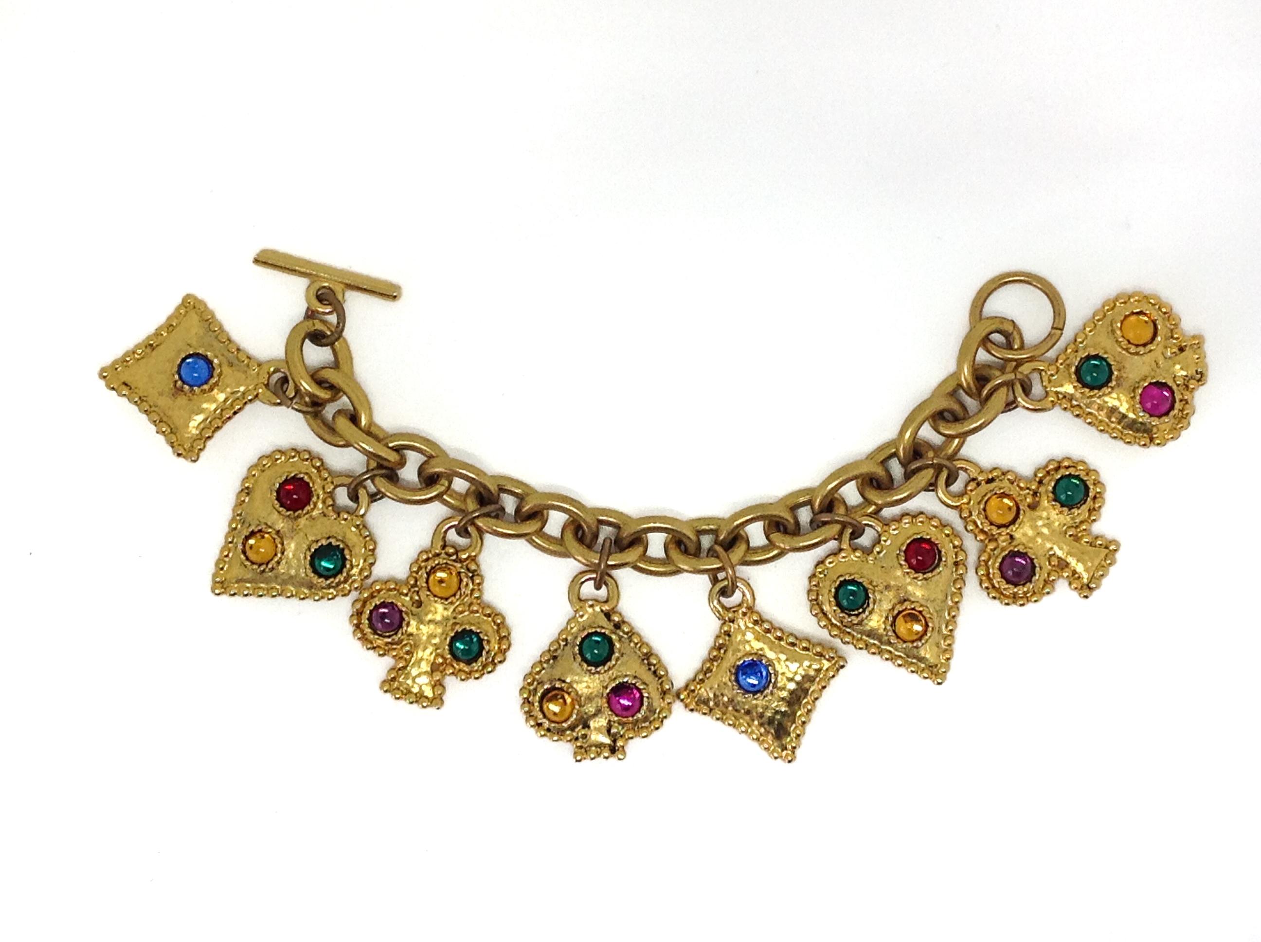 Eduard Rambaud 1980s Vintage Charm Bracelet 

Iconic 1980s statement piece from the very collectable Edouard Rambaud. Inspired by poker playing cards, this piece also comes with matching earrings. 

Materials
Gold plated metal, glass cabochons,