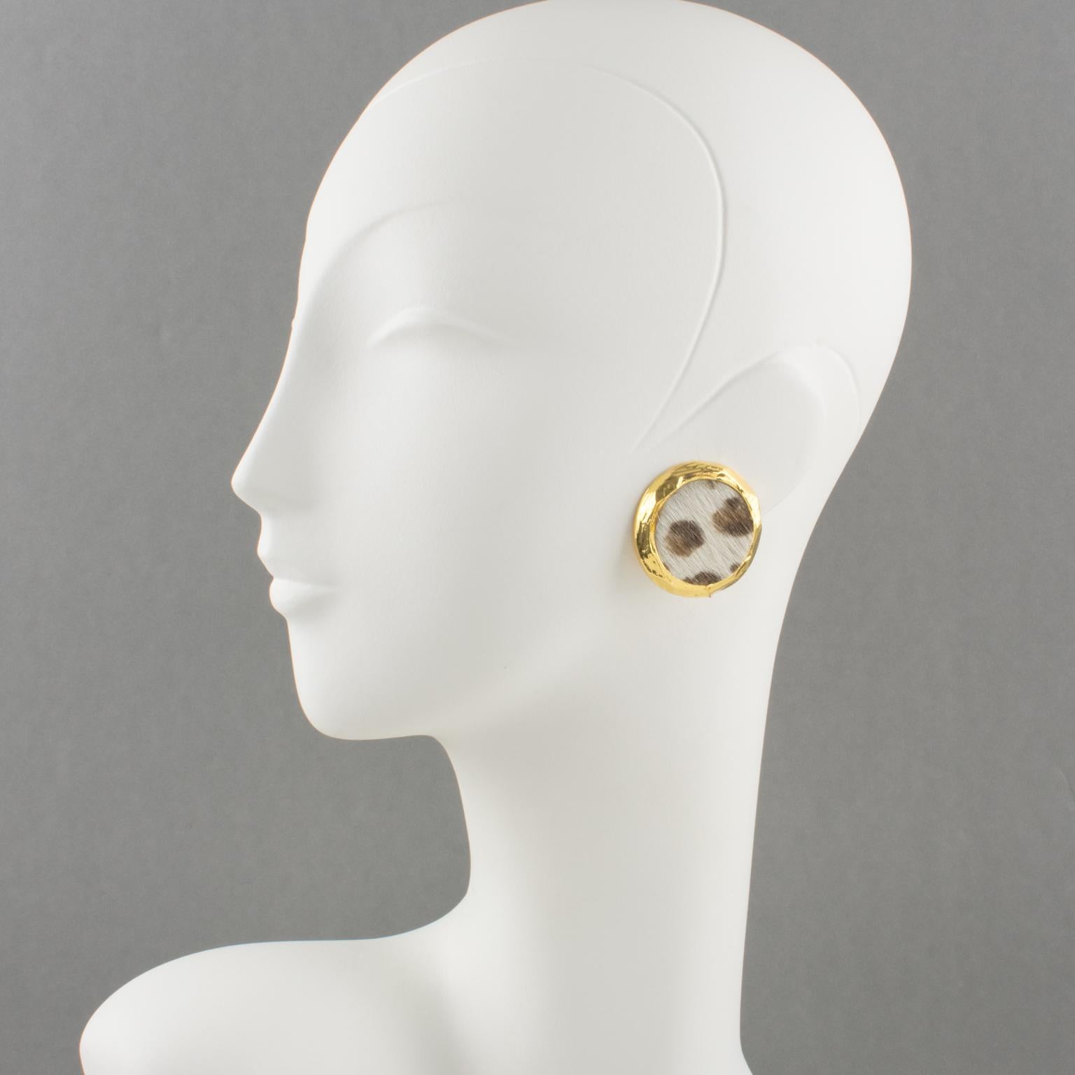 Elégantes boucles d'oreilles à clip du designer français Edouard Rambaud Paris. Forme géométrique arrondie avec métal doré brillant, entièrement texturé et surmonté de fausse fourrure en peau de poney à motif léopard. Signature du logo gravé sur la