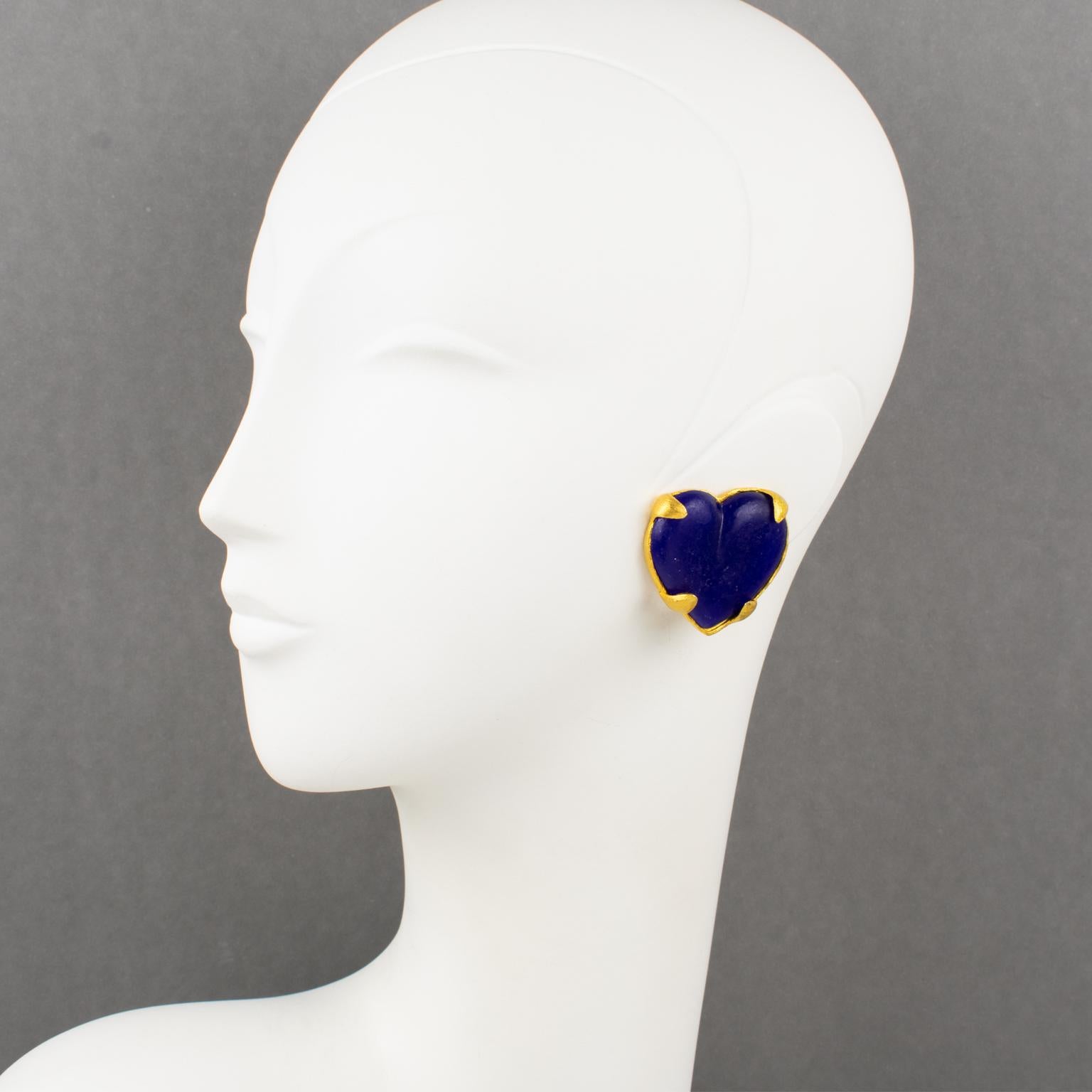 Lovely Edouard Rambaud Paris heart clip-on earrings. Dimensional oversized heart shape featuring gilt metal framing with mat finish aspect topped with cobalt blue resin heart-cabochon. Underside engraved signature is 