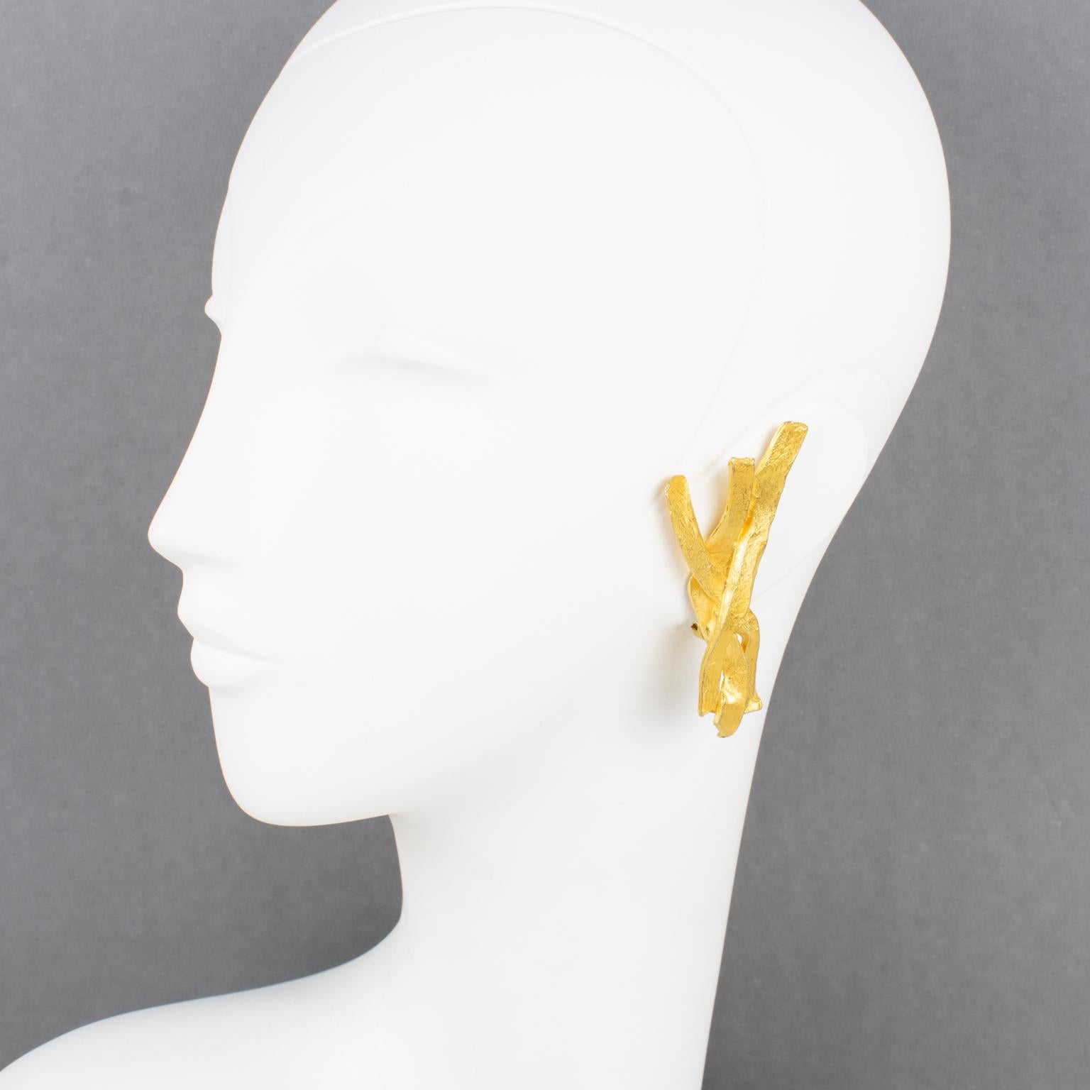 These elegant Edouard Rambaud Paris clip-on earrings feature a dimensional carved stylized branches-shaped design in textured gilt metal with a hand-made feel and satin finish aspect. They are signed with the designer's logo on the