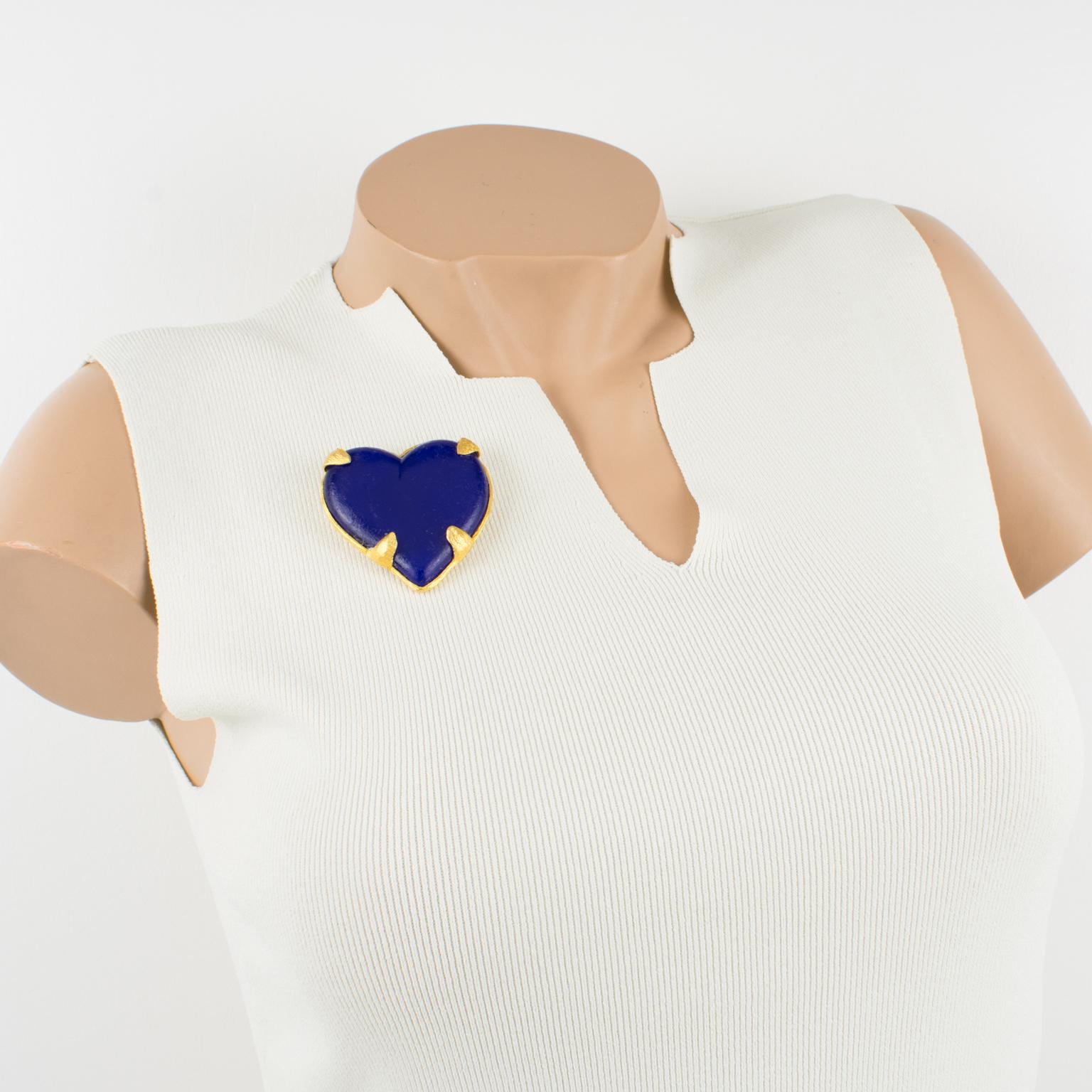 This stunning Edouard Rambaud Paris heart pin brooch features a dimensional oversized heart shape with gilded metal framing and a mat finish aspect topped with cobalt blue resin heart-cabochon. The pin has a security closing clasp at the back and