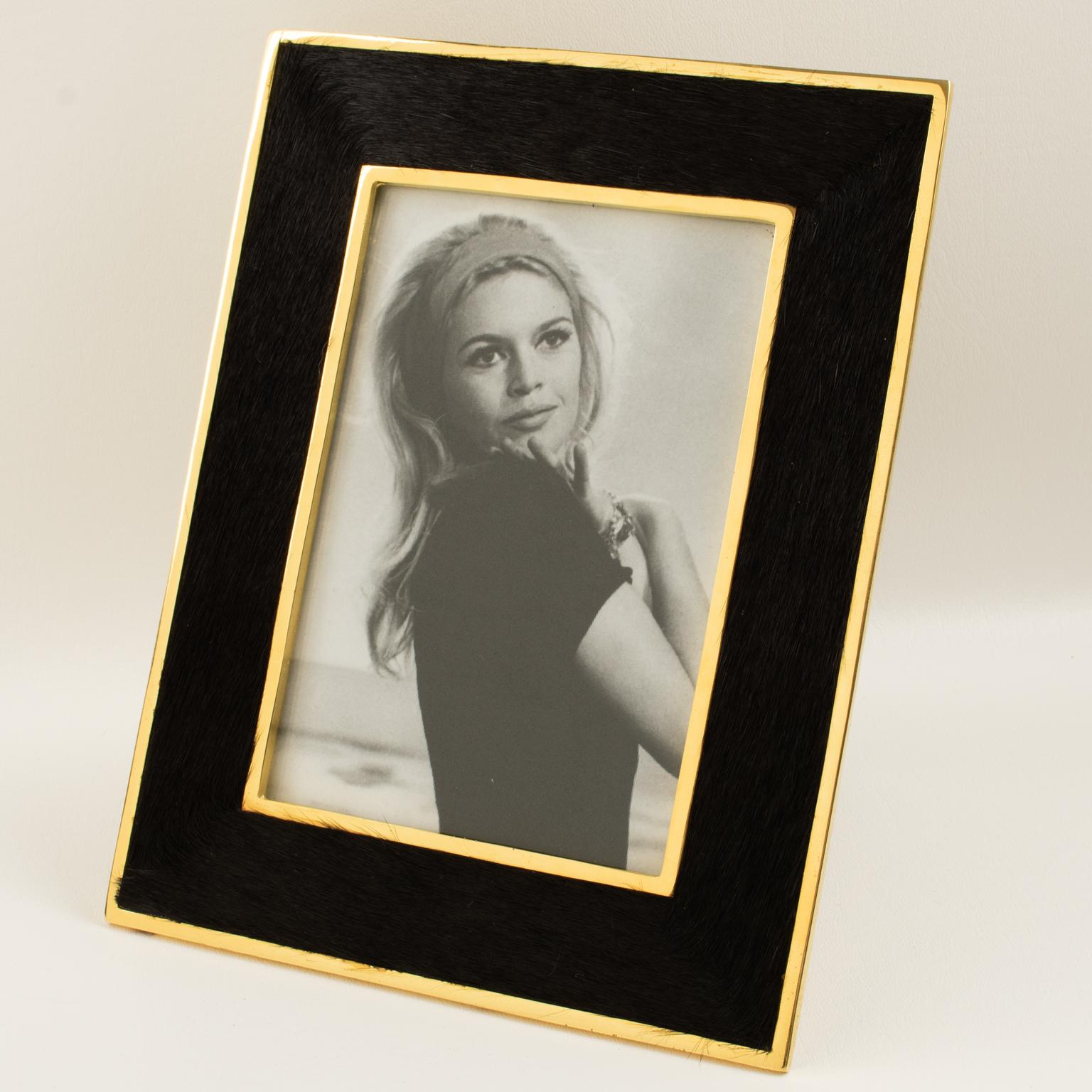 Le designer français Edouard Rambaud a conçu ce magnifique cadre photo en métal doré et fourrure dans les années 1980. La forme géométrique est encadrée de métal doré brossé et ornée de fourrure de poney. La fourrure du poney est d'une belle couleur