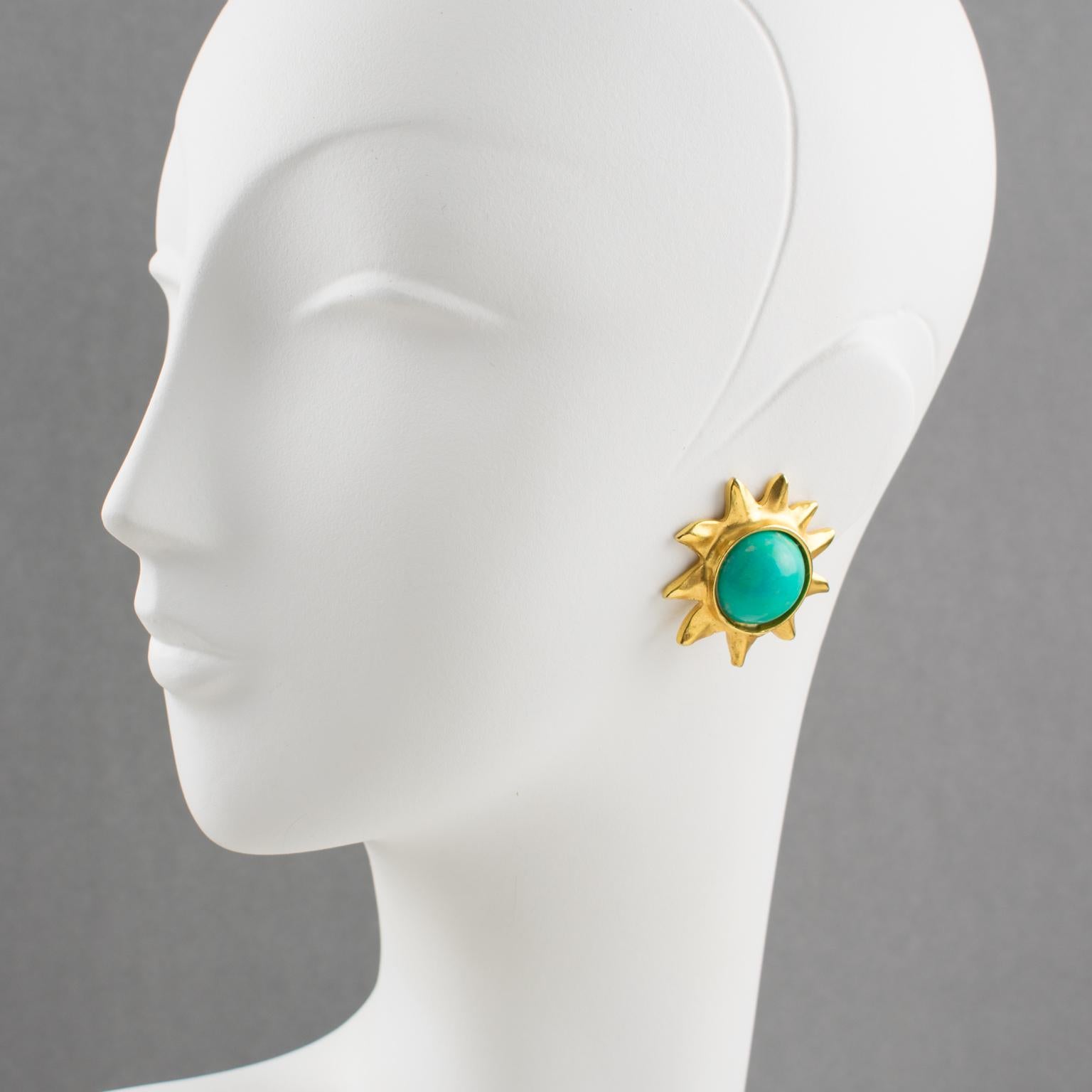 Elegant Edouard Rambaud Paris sun clip-on earrings. Dimensional carved sun with a gilt metal framing and mat finish aspect, topped with turquoise-like resin cabochon. Signed at the back by this well-known French designer. 
Measurements: 1.50 in.