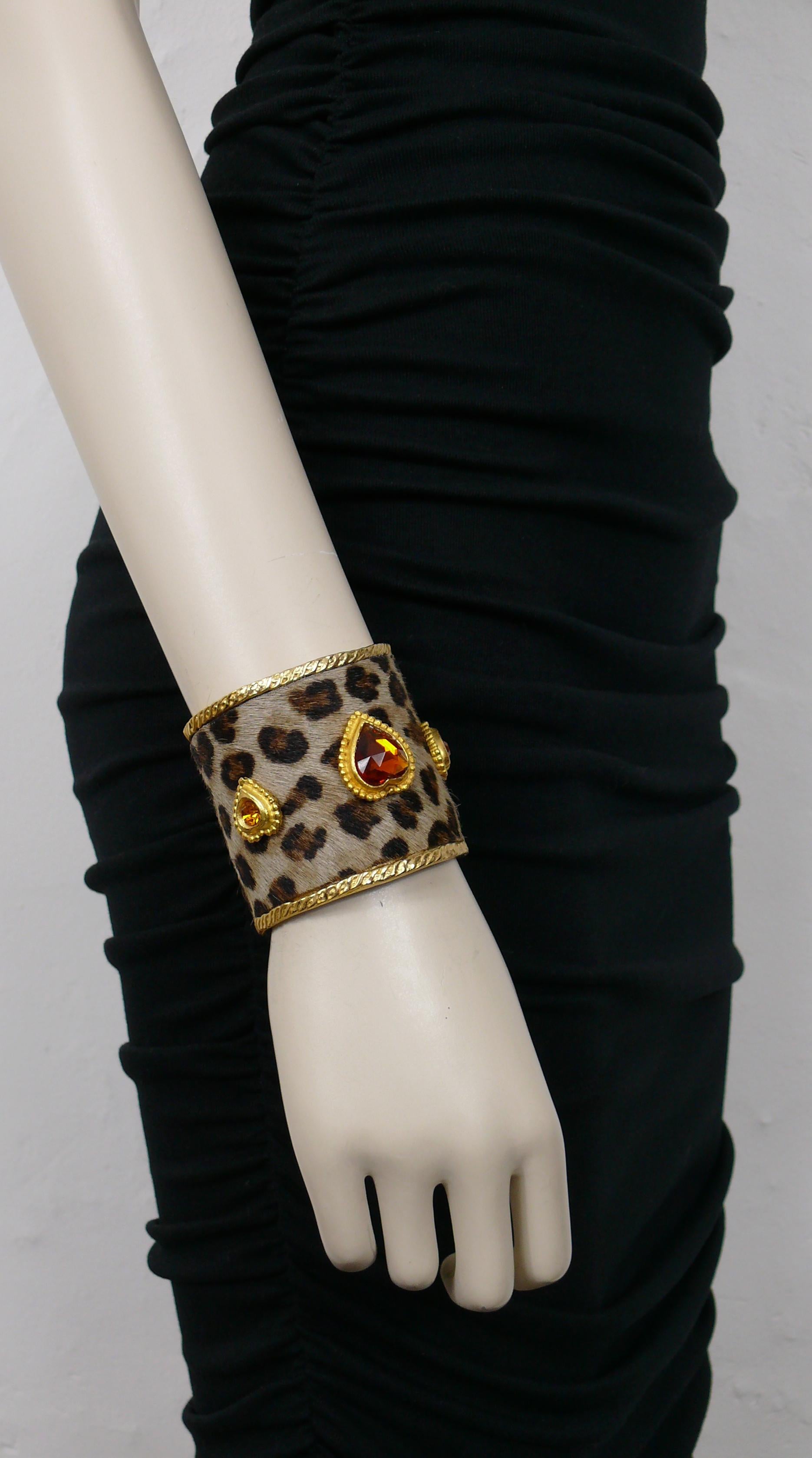 Bracelet manchette EDOUARD RAMBAUD vintage en or, avec une fausse peau de léopard et trois cœurs en or ornés de cristaux.

Gaufré EDOUARD RAMBAUD Paris.

Mesures indicatives : circonférence intérieure d'environ 16,34 cm (6,43 inches) / largeur