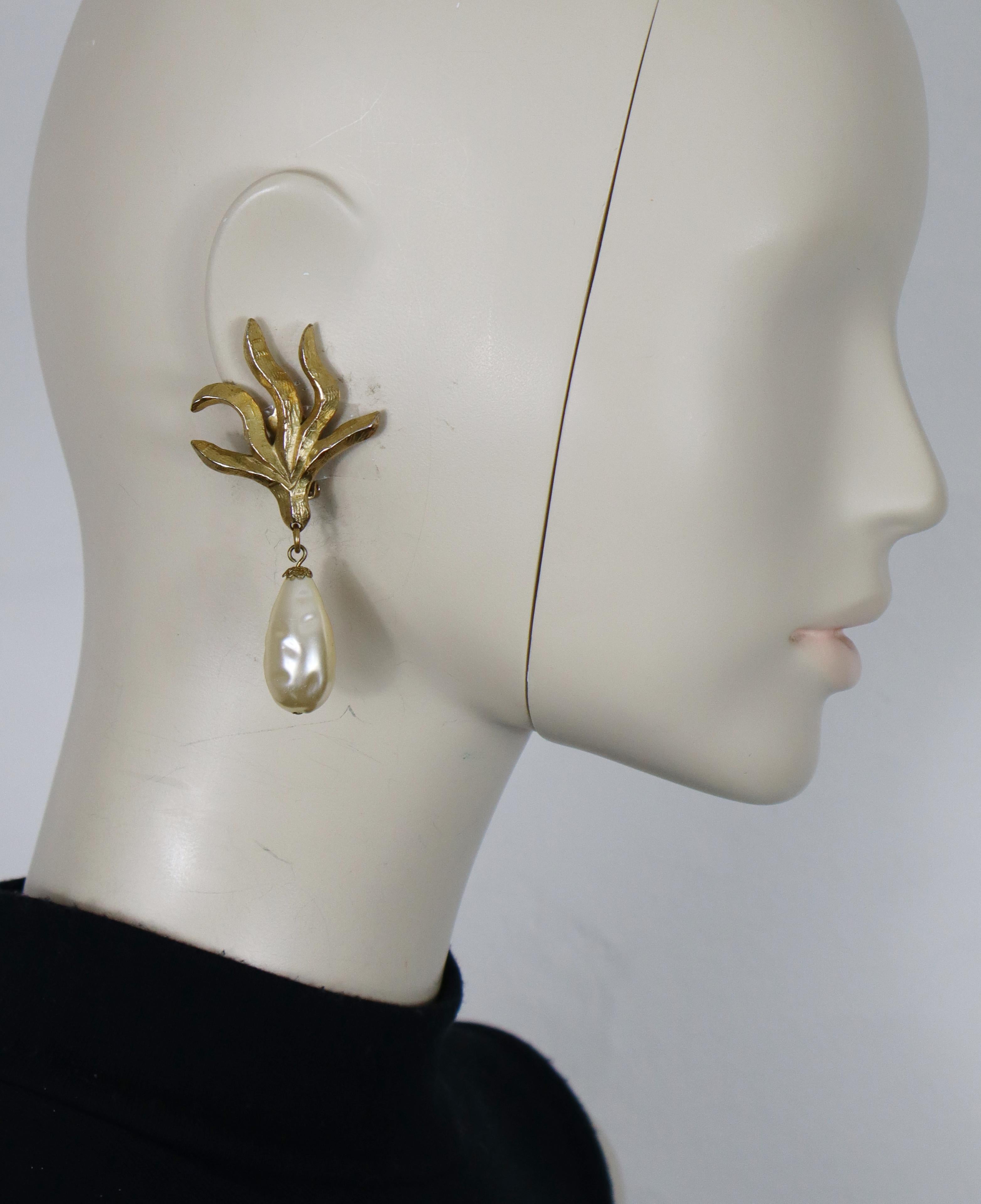 Pendientes colgantes EDOUARD RAMBAUD vintage con motivo de llama en tono dorado texturizado (de clip), adornados con una gota de perla de imitación de resina.

Grabado en relieve EDOUARD RAMBAUD París.

Medidas orientativas: altura aprox. 7,7 cm /