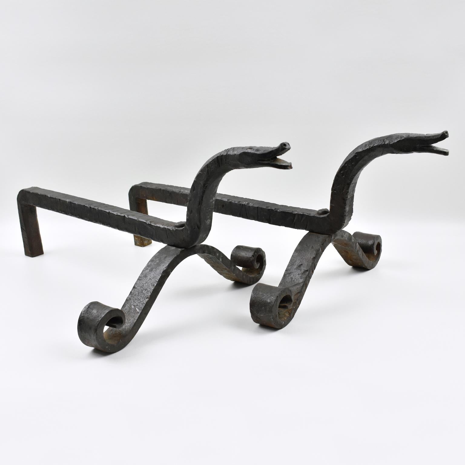 Outstanding pair of French wrought iron andirons in the manner of Edouard Schenck, early 20th Century. Dynamic form, with stylized carved snakeheads. No visible maker's mark.
Measurements: 12.19 in. wide (31 cm) x 22 in. deep (56 cm) x 9.44 in.