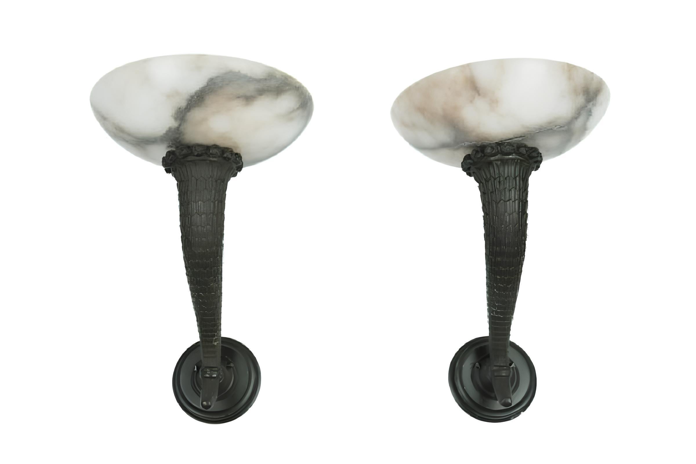 Wall Sconces designed by Edouard Schenck in bronze with alabaster shades. These wall sconces were often used by Émile-Jacques Ruhlmann in his interior designs between 1913 and 1918. This model was featured in the bedroom design for Fernande Cabanel,