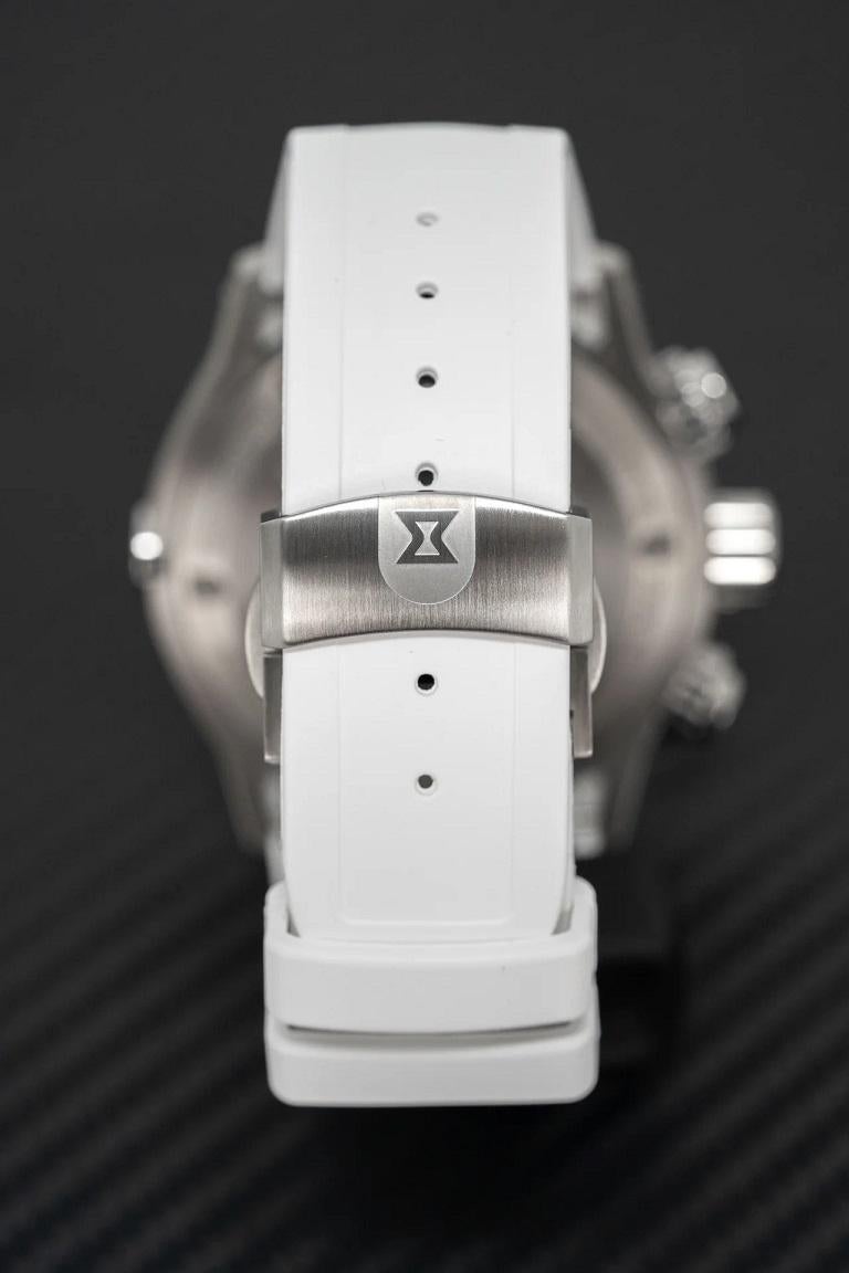 White titanium case with a white rubber strap. White ceramic bezel. White dial with silver-tone hands and index hour markers. Minute markers around the outer rim. Dial Type: Analog. Luminescent hands and markers. Date display at the 4 o'clock