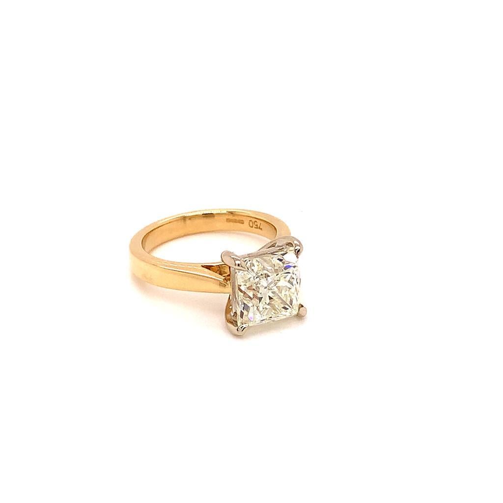 Un magnifique diamant taille princesse de 3,65 carats est au centre de cette captivante bague en or jaune 18 carats. La pierre solitaire scintillante, de couleur J et de pureté VVS1, est sertie d'une monture à quatre griffes qui maintient ce bijou