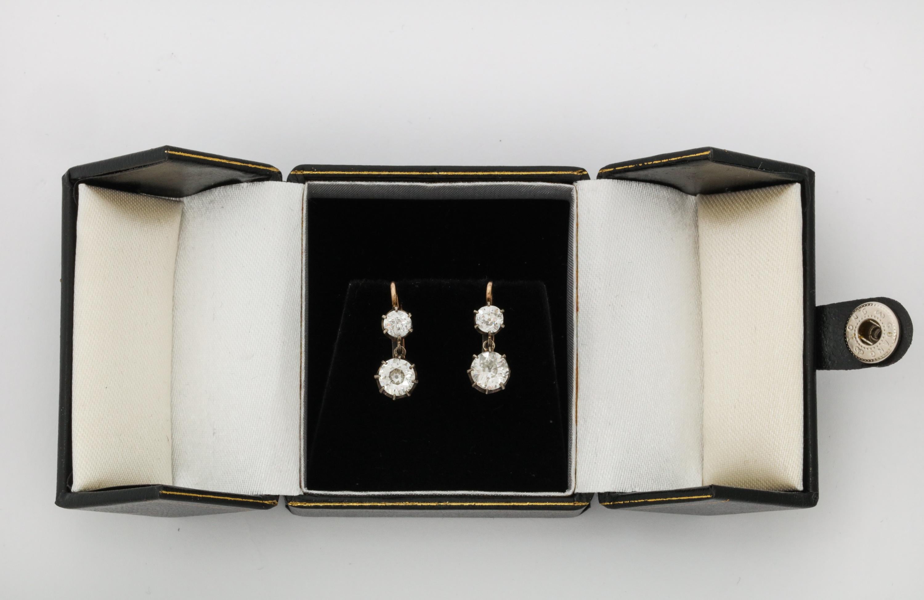 One Pair Of Ladies 18kt Gold Two Stone Diamond Drop Earrings Designed With Two Larger Antique Cut Diamonds Weighing Approximately .70 ct Each On Top Of Earrings Two Antique Cut Diamonds Weighing Approximately .30 Ct Each. Total Diamond Weight