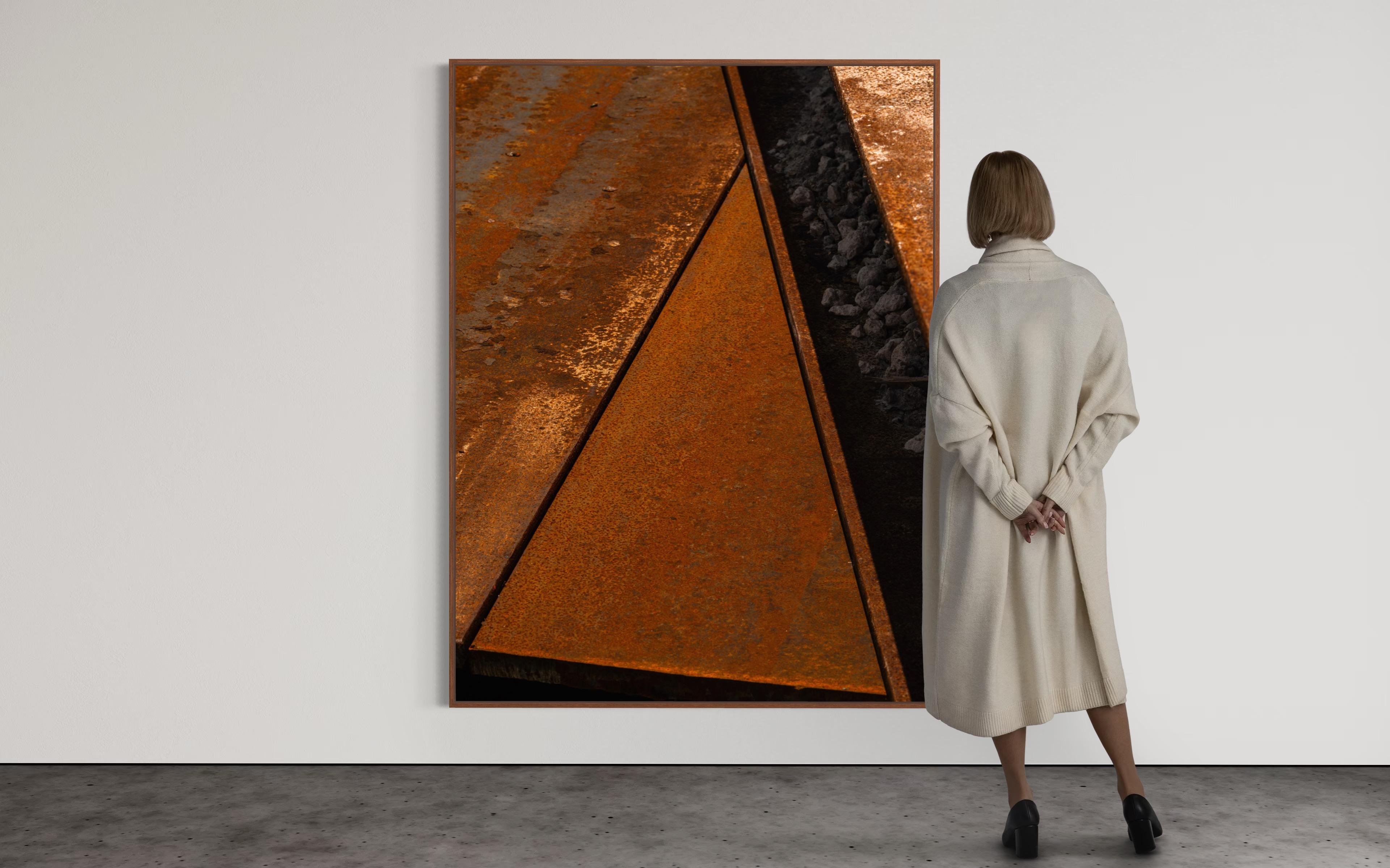 Part of Eduardo Rezende’s Trama series, this work reveals the artist’s exploration of material abstraction through construction surfaces. The image captures oxidized steel panels intersecting in sharp geometric lines, where corrosion and shadow