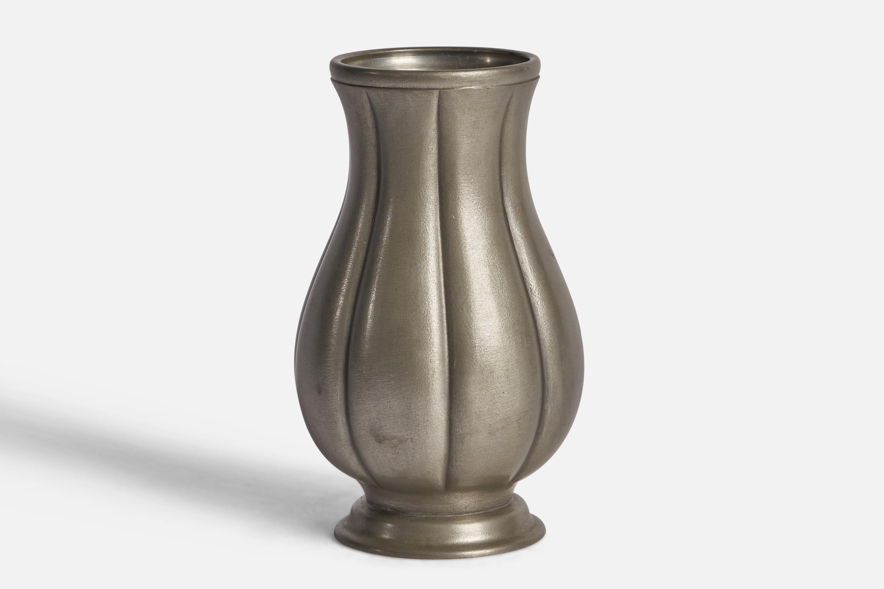 A fluted pewter vase designed by Edvin Ollers and produced by Shreuder & Olson,, Sweden, 1952.

“GJUTET TENN” stamp on bottom