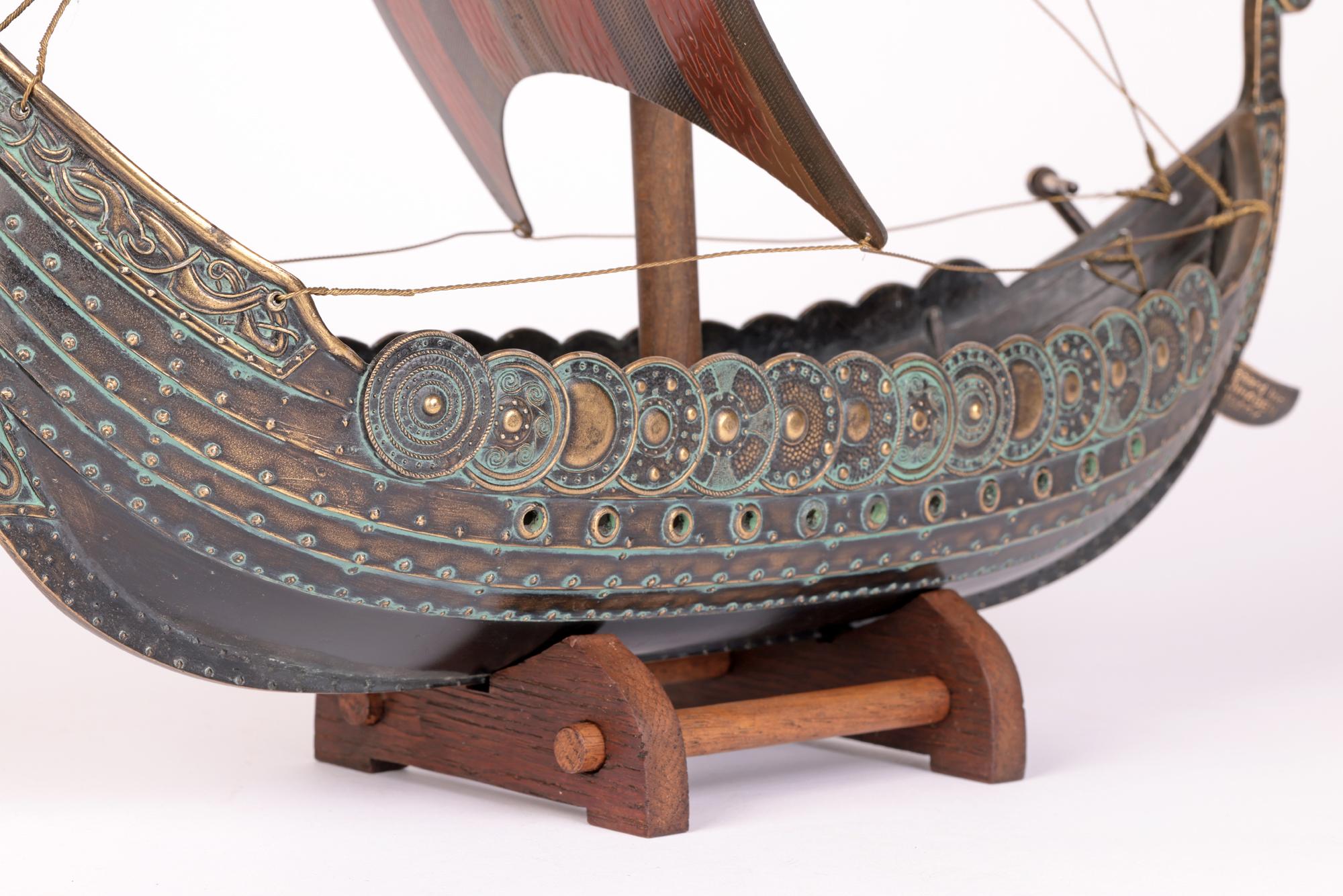 A stylish and impressive Danish mid-century bronze model of a Viking ship designed by Edward Aagaard and dating from around 1960. Made in Copenhagen the heavily made ship has a raised dragon figure head to the fore and a raised tail to the rear with