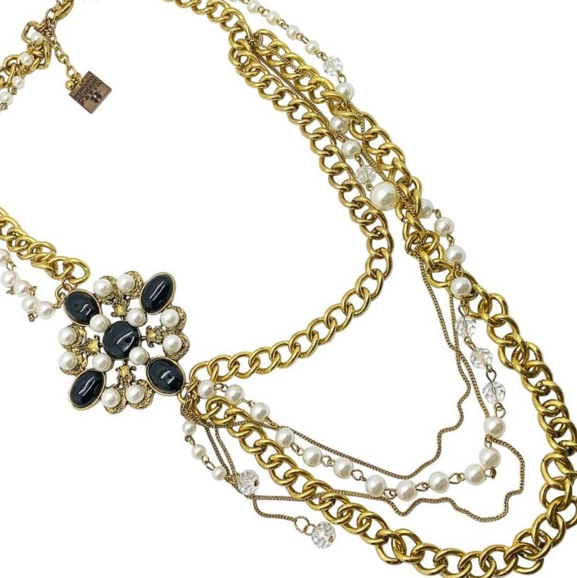 An impressive Edward Achour chain necklace. Featuring multiple chains interspersed with pearls and a cruciform style plaque.

Condition: Very good without damage or noteworthy wear.
Materials: gold plated metal, resin simulated pearls, resin stones,