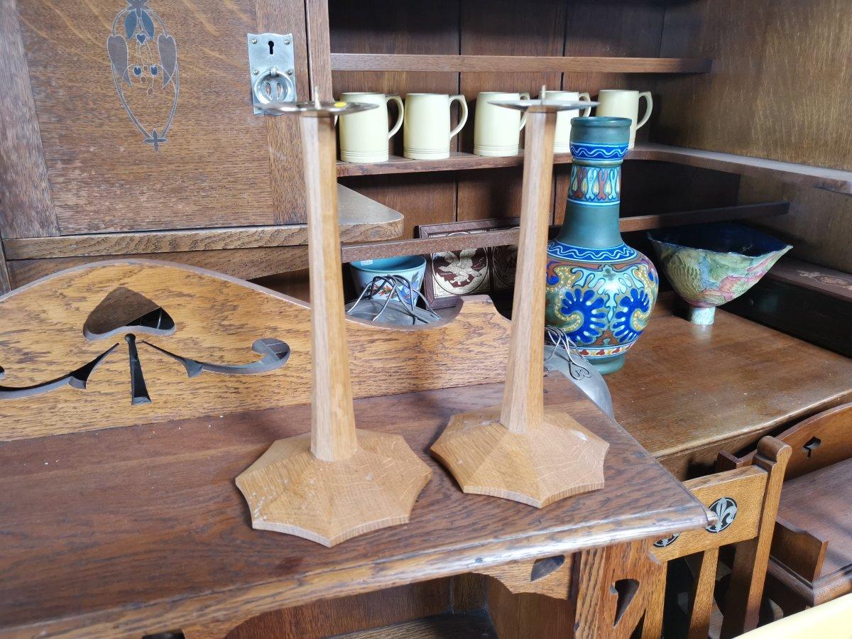 Edward Barnsley stamped signature to the base.
A pair of Arts & Crafts oak candlesticks with brass drip-trays, octagonal stems and spider web style bases.