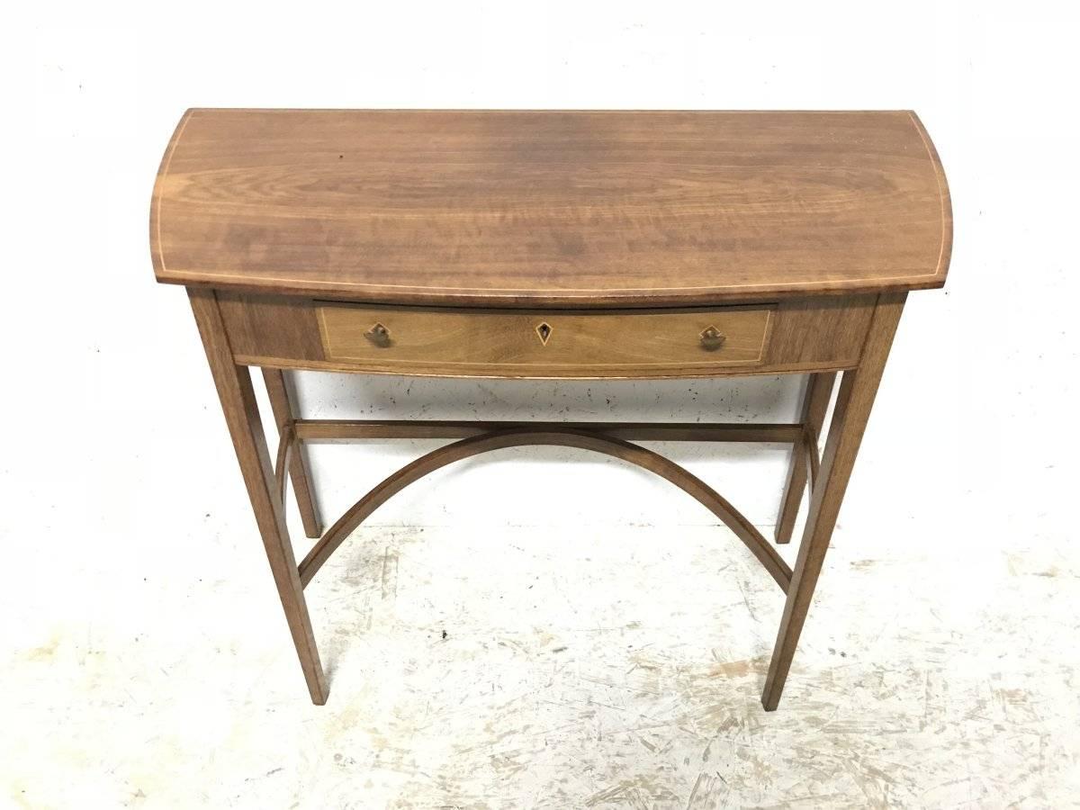 Edward Barnsley workshop, a fine sycamore and holly wood inlaid writing or side table with a shaped top and brass crescent shaped handles and an inlaid escutcheon plate. Stood on five sided legs united by a double serpentine stretcher.
Stamped