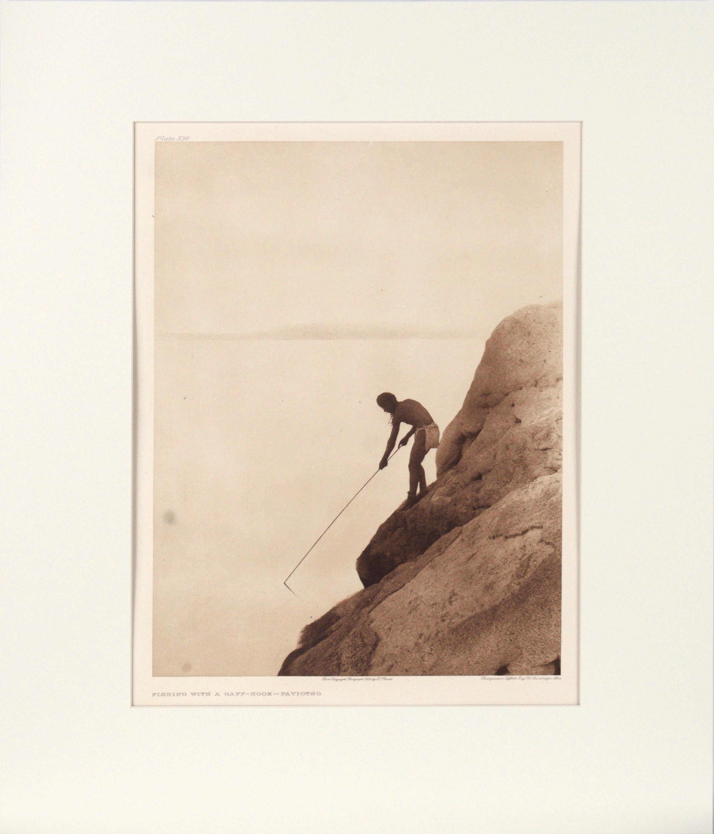 Edward Curtis Landscape Print - "Fishing with a Gaff Hook - Paviotso" Photogravure of a Native American Man