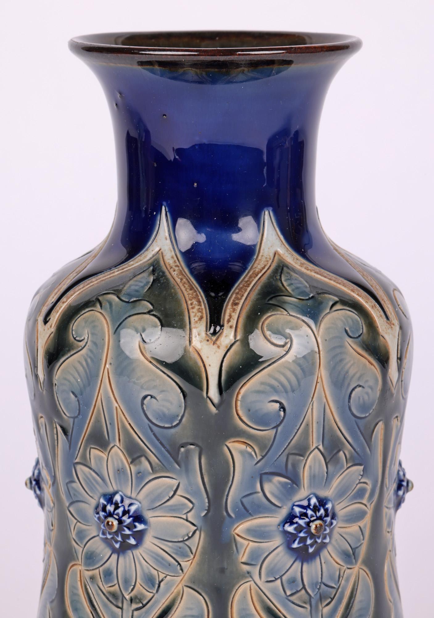 A stunning Doulton Lambeth Aesthetic Movement vase decorated with stylised floral and leaf designs by renowned artists Edward Dunn and Rosina Brown and dated 1884. The stoneware vase stands on a narrow round unglazed foot with slightly recessed base