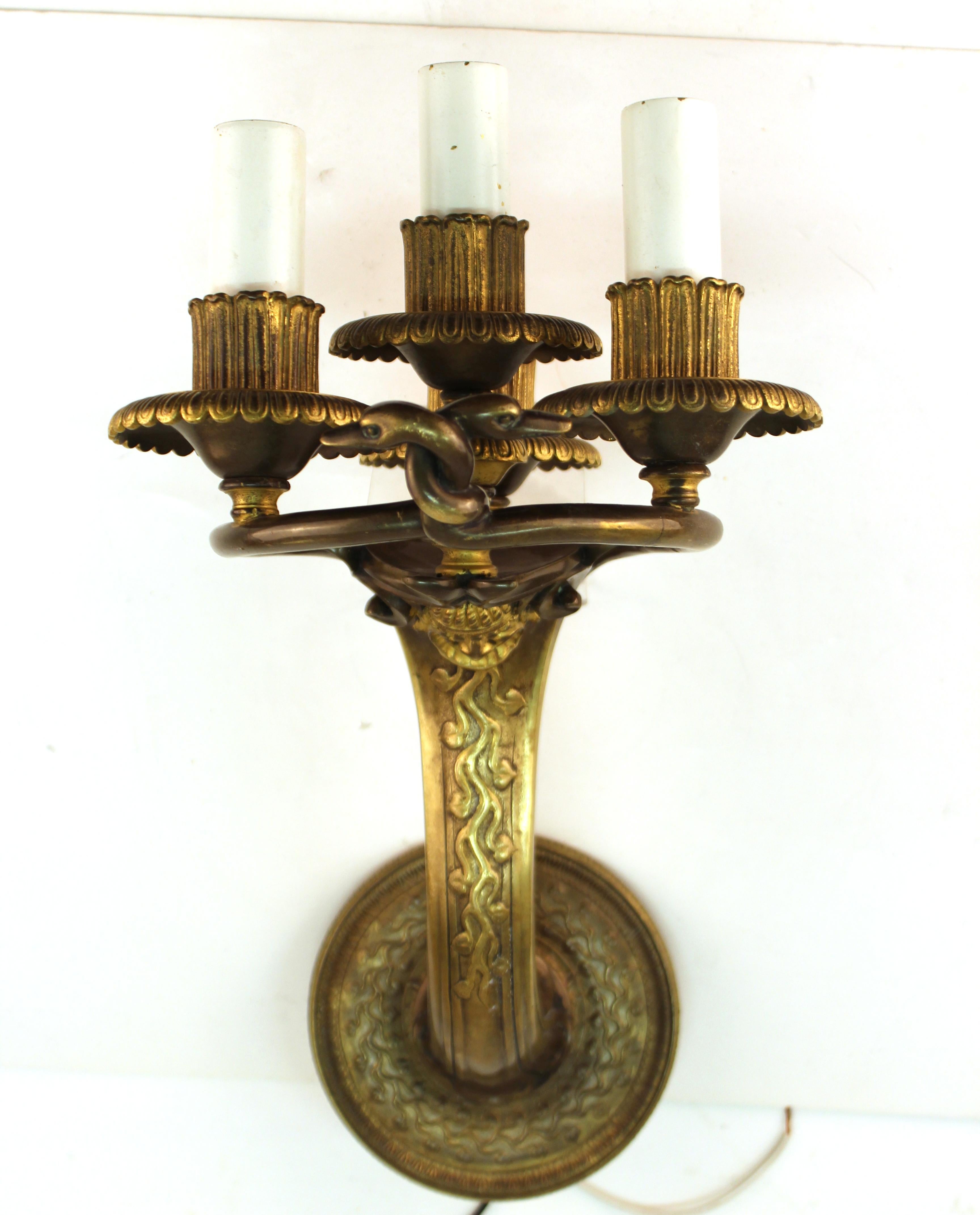 American neoclassical revival pair of patinated gilt bronze sconces created by Edward F. Caldwell & Co. in New York City, possibly for a theatre. The pair dates from the circa 1910s and has a Caldwell mark on the backside. In great vintage condition