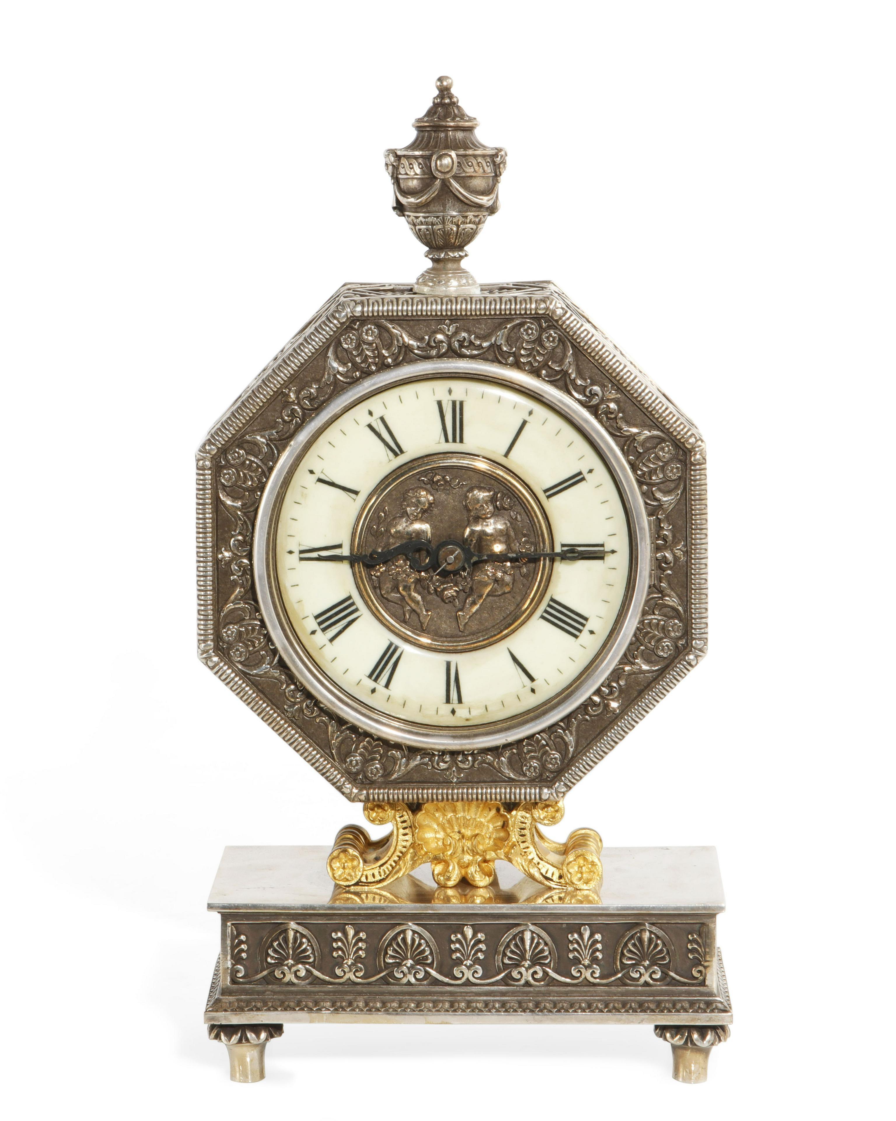 Edward F. Caldwell & Co., an American gilt and silvered bronze table clock, circa 20th century.

Very high quality clock. 

Enamel face and central reserve of two cherubs.

A nearly identical example, entgilt bronze, signed for E.F. Caldwell