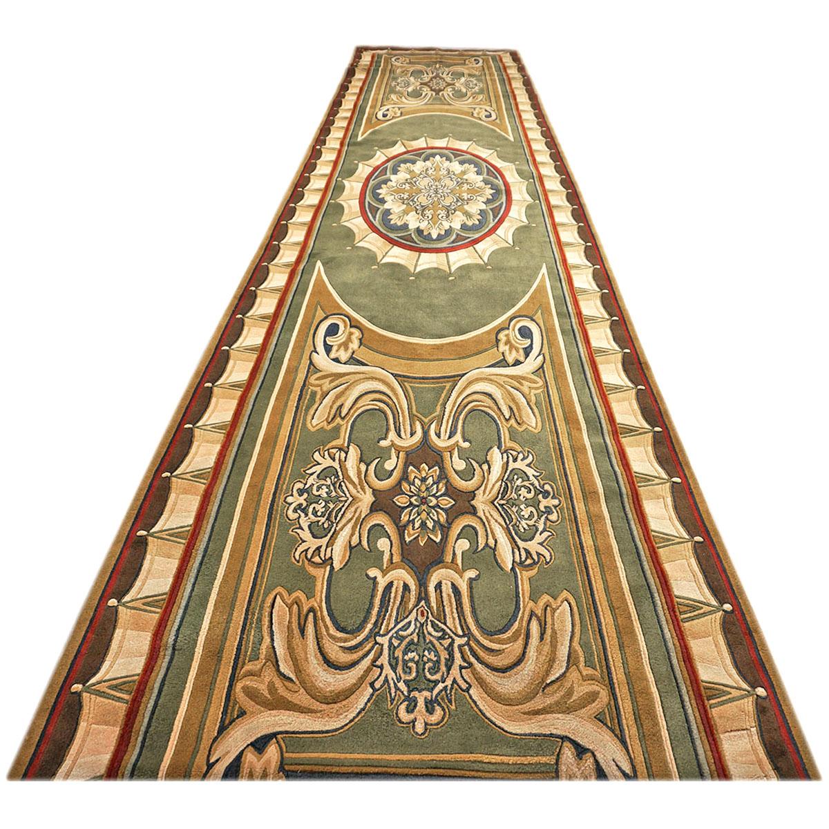 Ashly Fine Rugs presents a 20th-century Vintage French Savonnerie 6x29 green and gold hand-tufted gallery-sized runner. It was custom ordered and created by Edward Fields Long Island NY in a French Savonnerie design in the 1960s. French Savonnerie