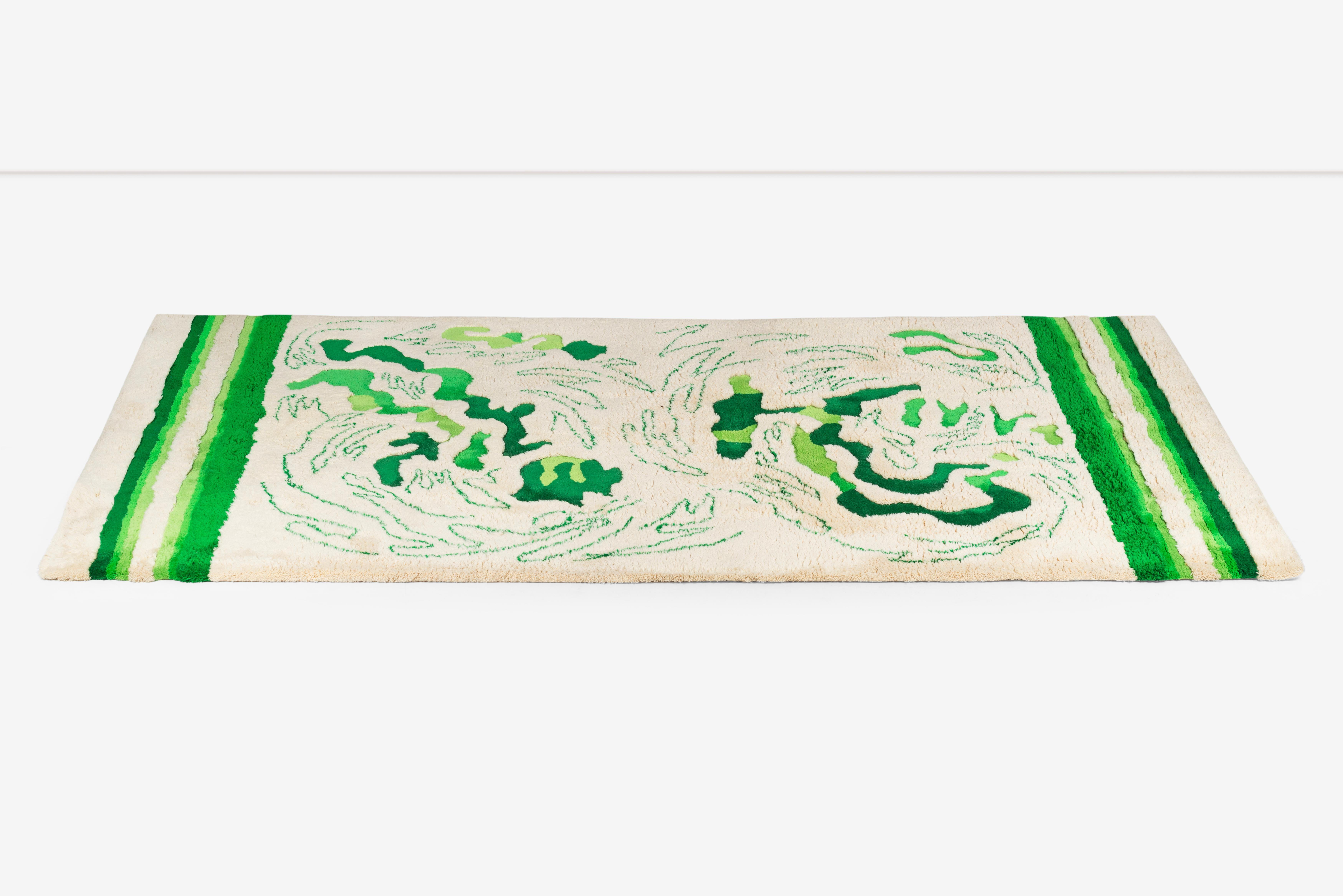 Edward fields rug with cream background and green camo like squiggles and abstract expressionisms.