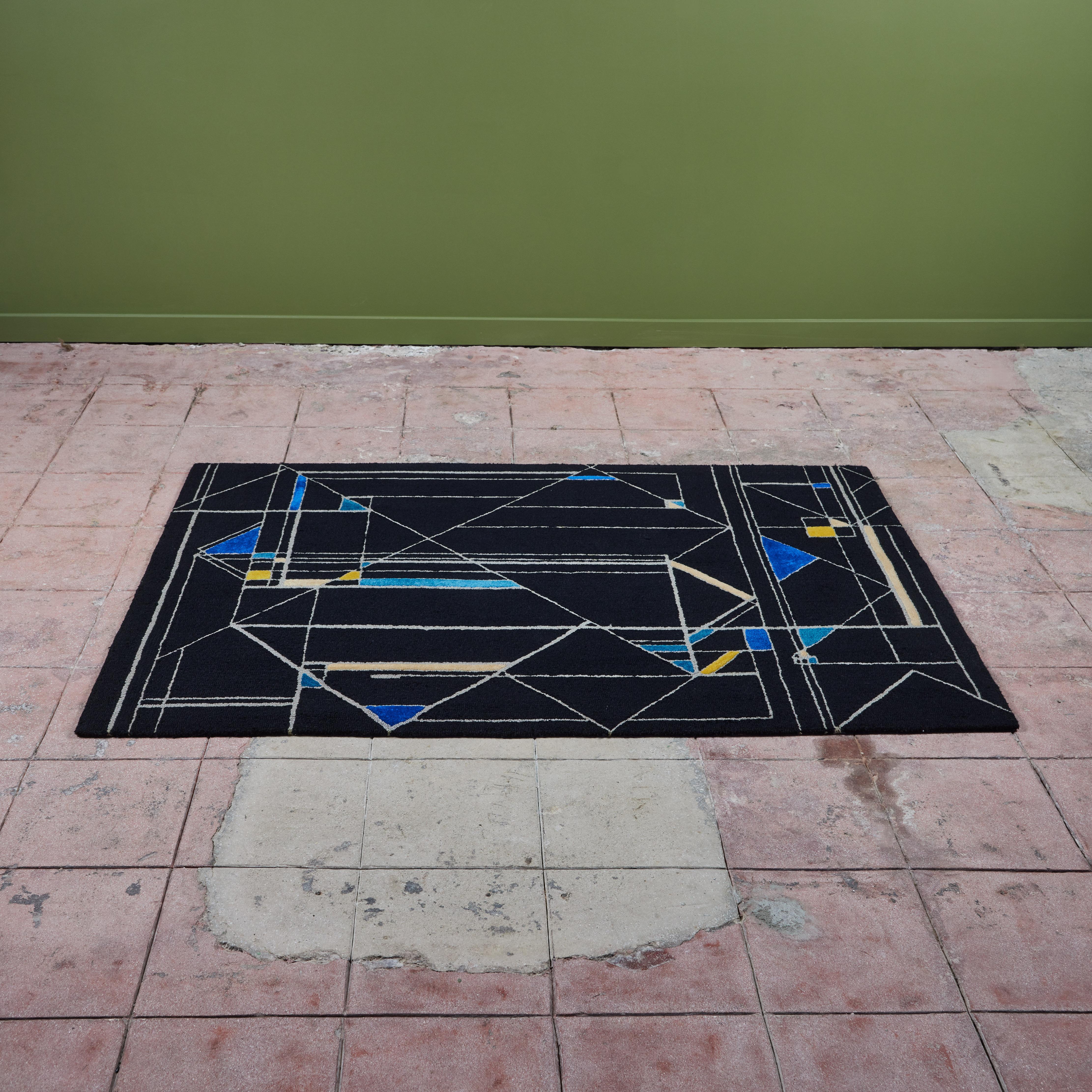 Edward Fields rug, c.1970s, USA. This wool rug features a geometric pattern of varying rectangles and triangles in hues of black, blue, yellow and cream. Signed on the back.

Dimensions
71.5