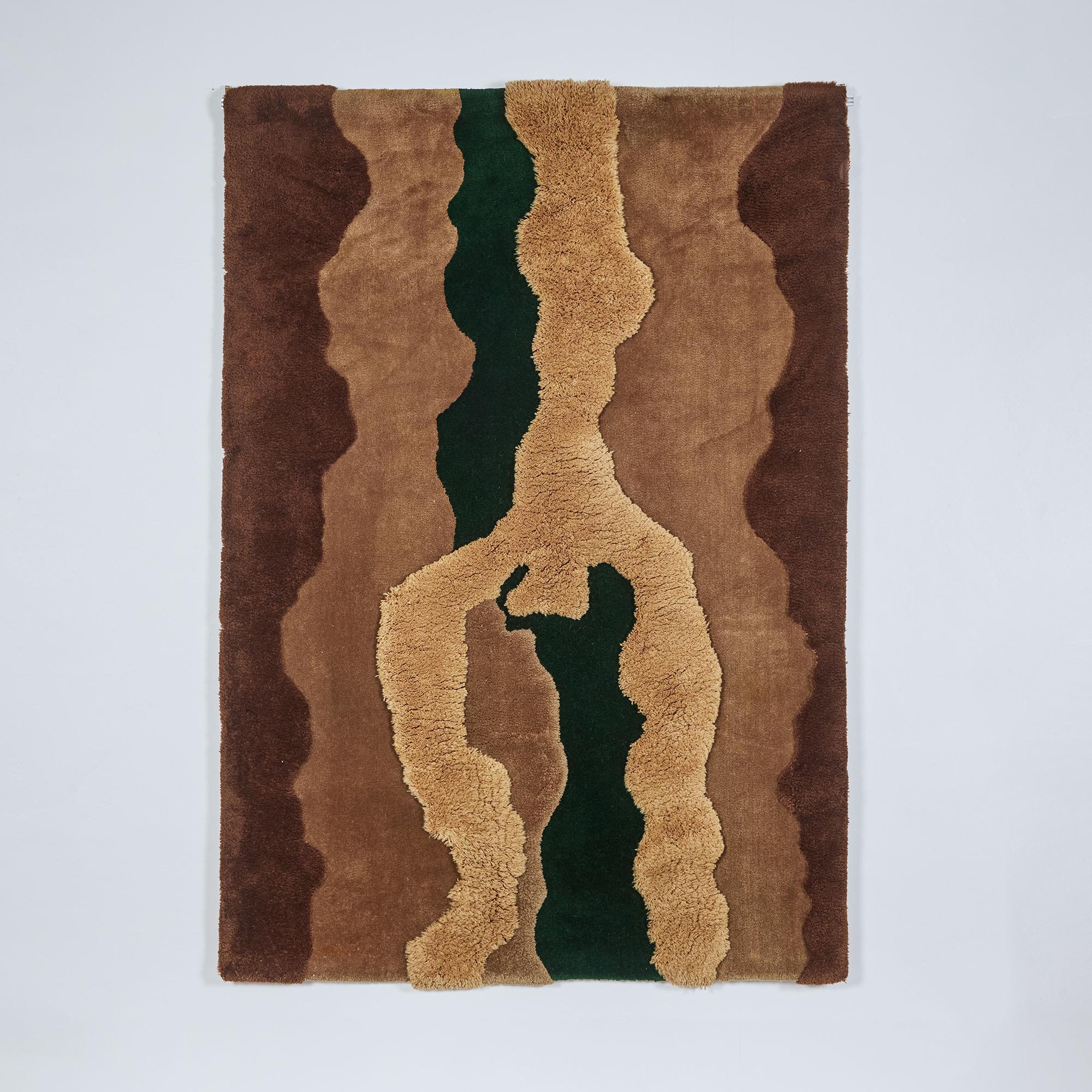 Edward Fields rug or tapestry, c.1970s, USA. This hand knotted wool rug features varying pile heights that add depth and texture to the piece. Its color ranges in tones of brown, caramel and tan with one section of deep forest green. This piece has