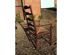 An English Cotswold School Oak Ladder Back Rush Seat Armchair