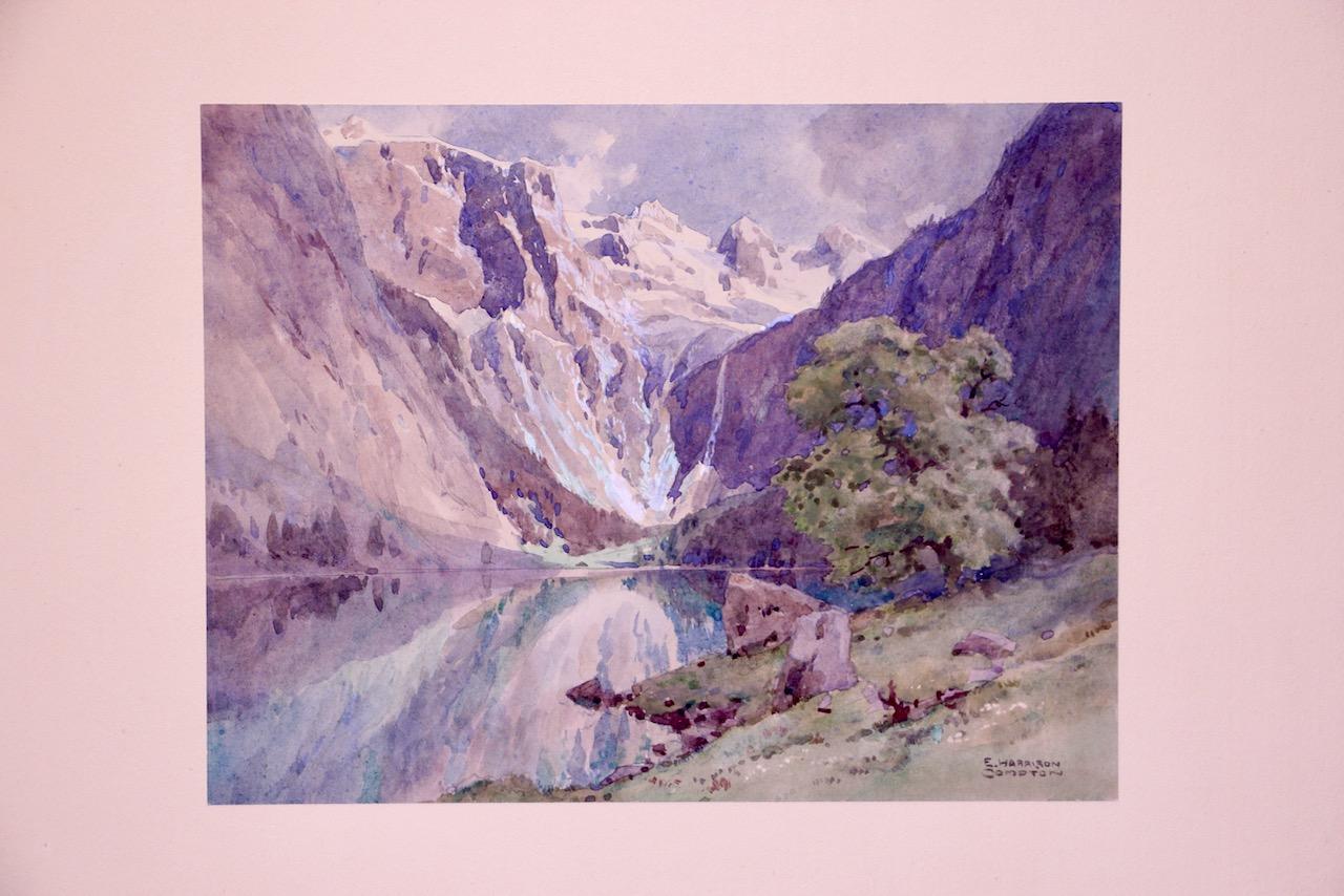 Eine fein detaillierte Alpenlandschaft in Aquarell und Gouache des in Großbritannien geborenen deutschen Malers Edward Harrison Compton (1881-1960), signiert unten rechts. Die Komposition zeigt einen ruhigen Bergsee, der von steilen Felswänden und