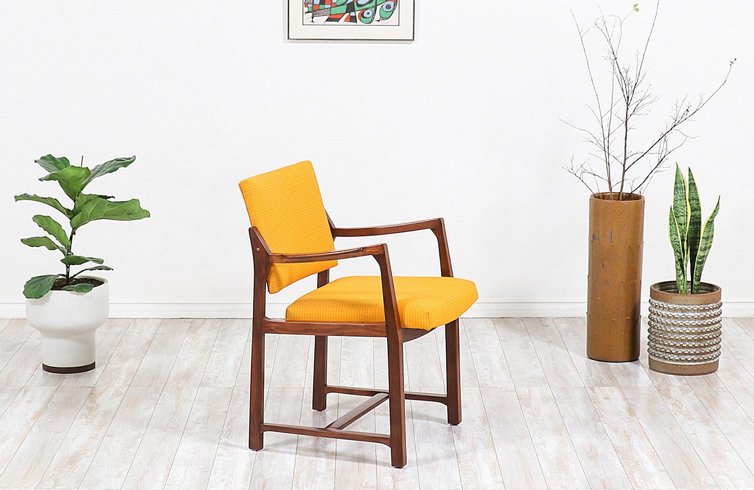 Beautiful Mid-Century Modern armchair designed by American furniture designer, Edward J. Wormley, for Dunbar in the United States, circa 1950s. This sleek design features a solid walnut wood frame with soft curvilinear arms and a geometric base