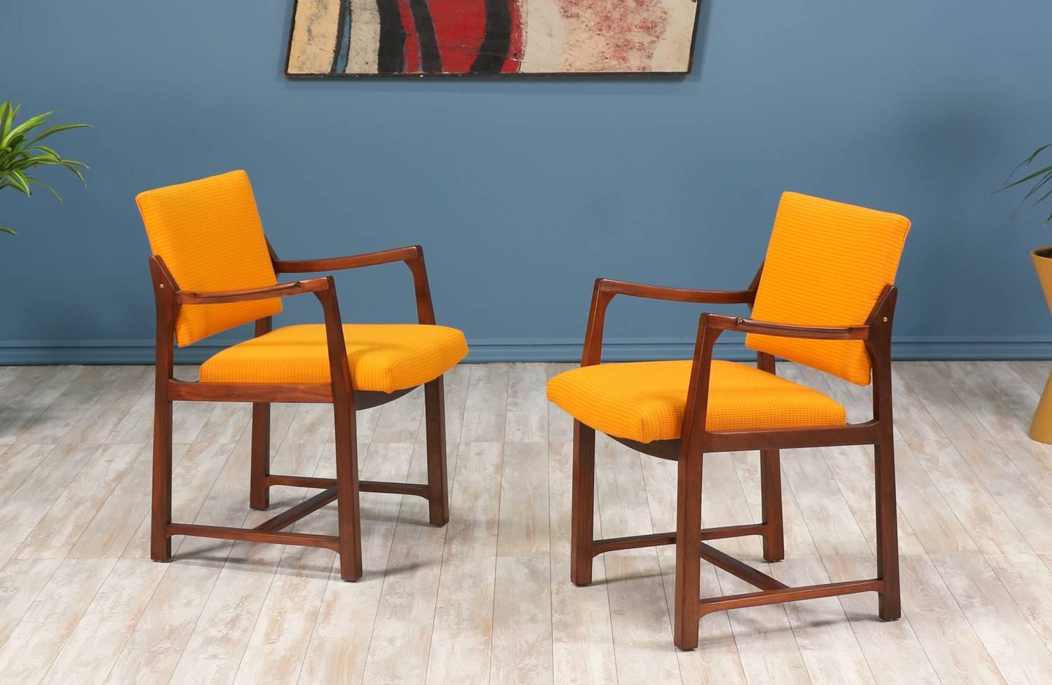 A pair of Mid-Century Modern lounge chair designed by American furniture designer, Edward J. Wormley, for Dunbar in the United States circa 1950’s. These chairs feature a streamline walnut wood frame with the seat and back reupholstered in a vintage