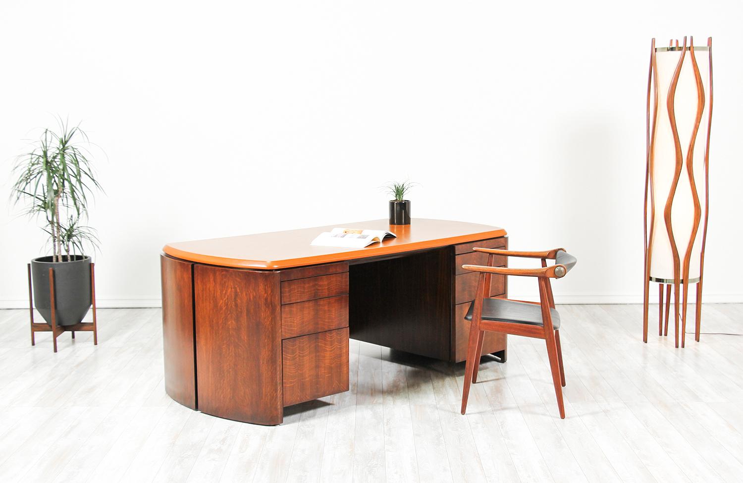 Beautiful and rare executive desk designed by Edward J. Wormley for Dunbar in the United States, circa 1950s. It features an elegant full-grain rust colored leather top on a walnut veneered hardwood frame. The front shows six drawers that vary in