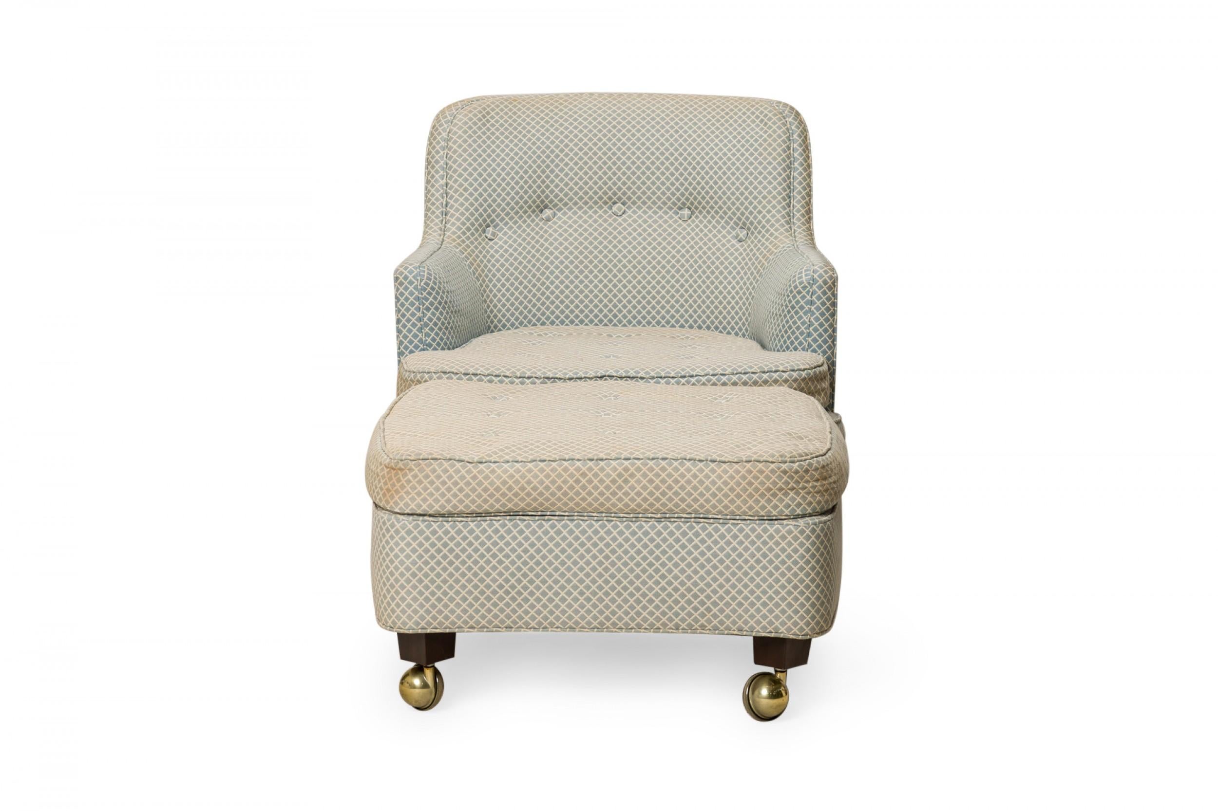 American Mid-Century rolling boudoir / lounge armchair and matching ottoman, upholstered in a light blue and white diamond patterned fabric with button tufted back detail, both resting on short walnut legs ending in brass ball casters.(EDWARD J