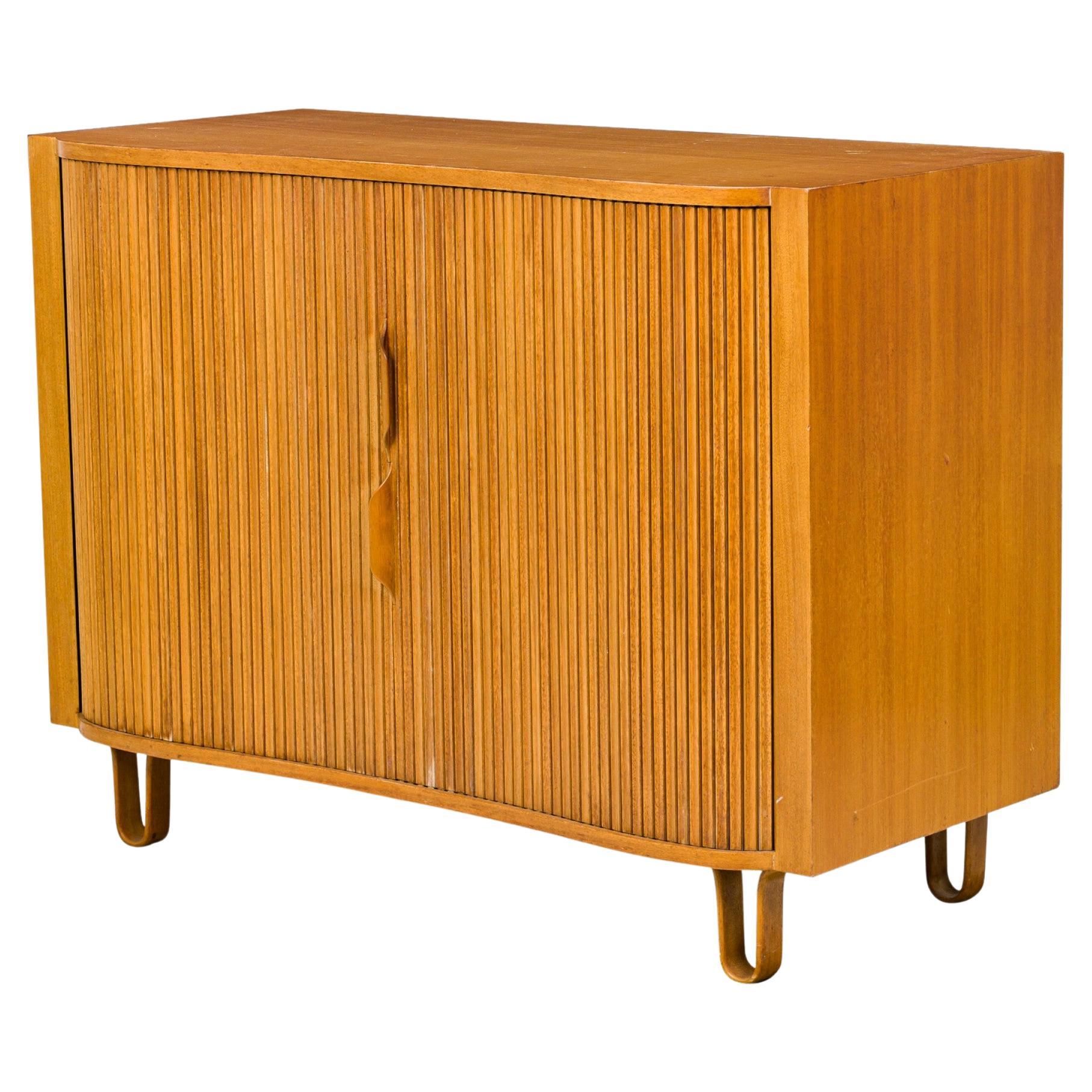 Armadio in noce del Mid-Century americano composto da due sezioni adiacenti con due ante a rullo, la sinistra con 4 cassetti estraibili più grandi e la destra con 8 cassetti di dimensioni alterne, che poggiano su quattro gambe a U in legno curvato.