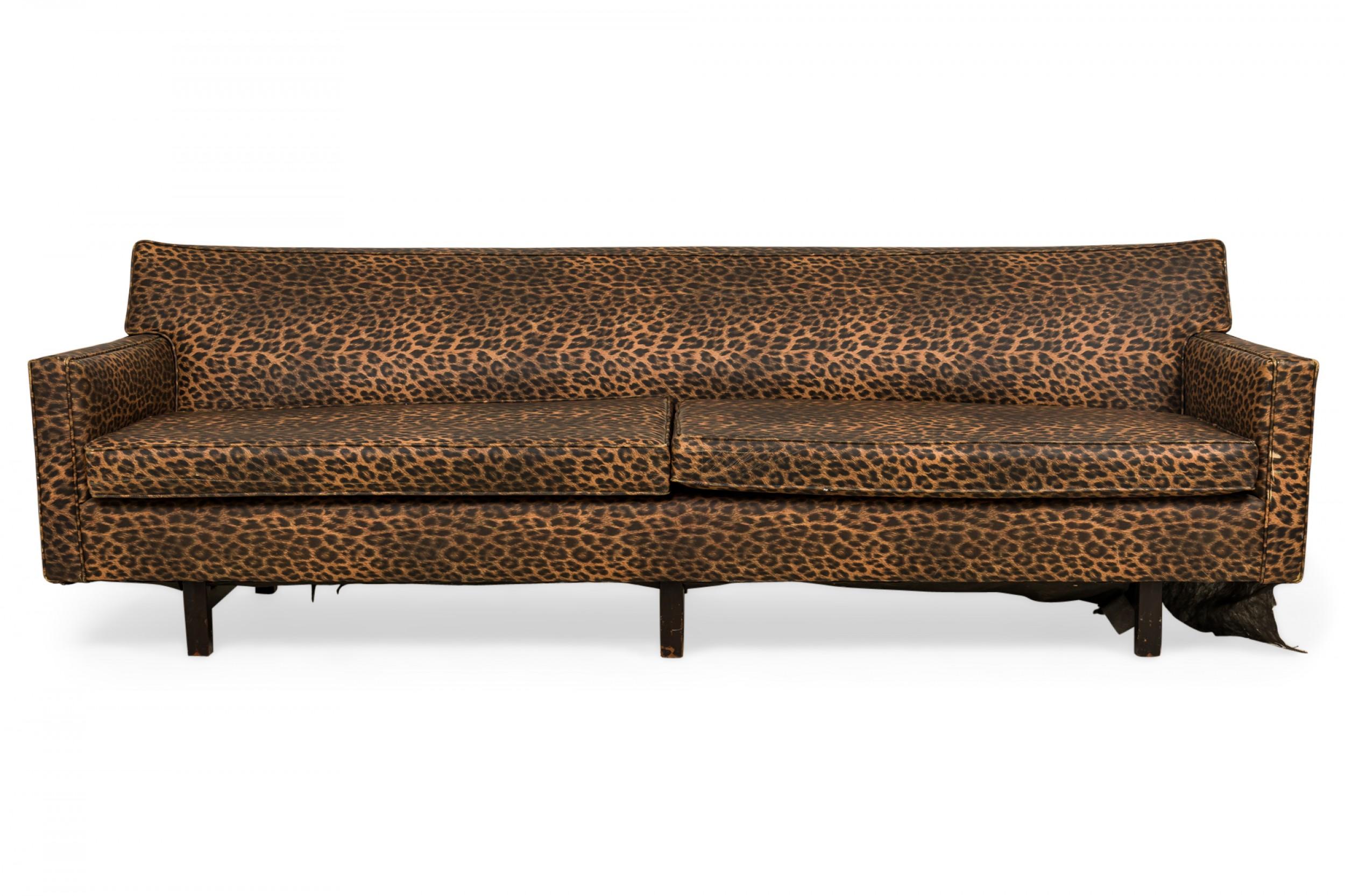 American Mid-Century three seat sofa, upholstered in a brown and black leopard print vinyl with two removable seat cushions, resting on three sets of square walnut legs. (EDWARD J WORMLEY FOR DUNBAR FURNITURE COMPANY).
 
