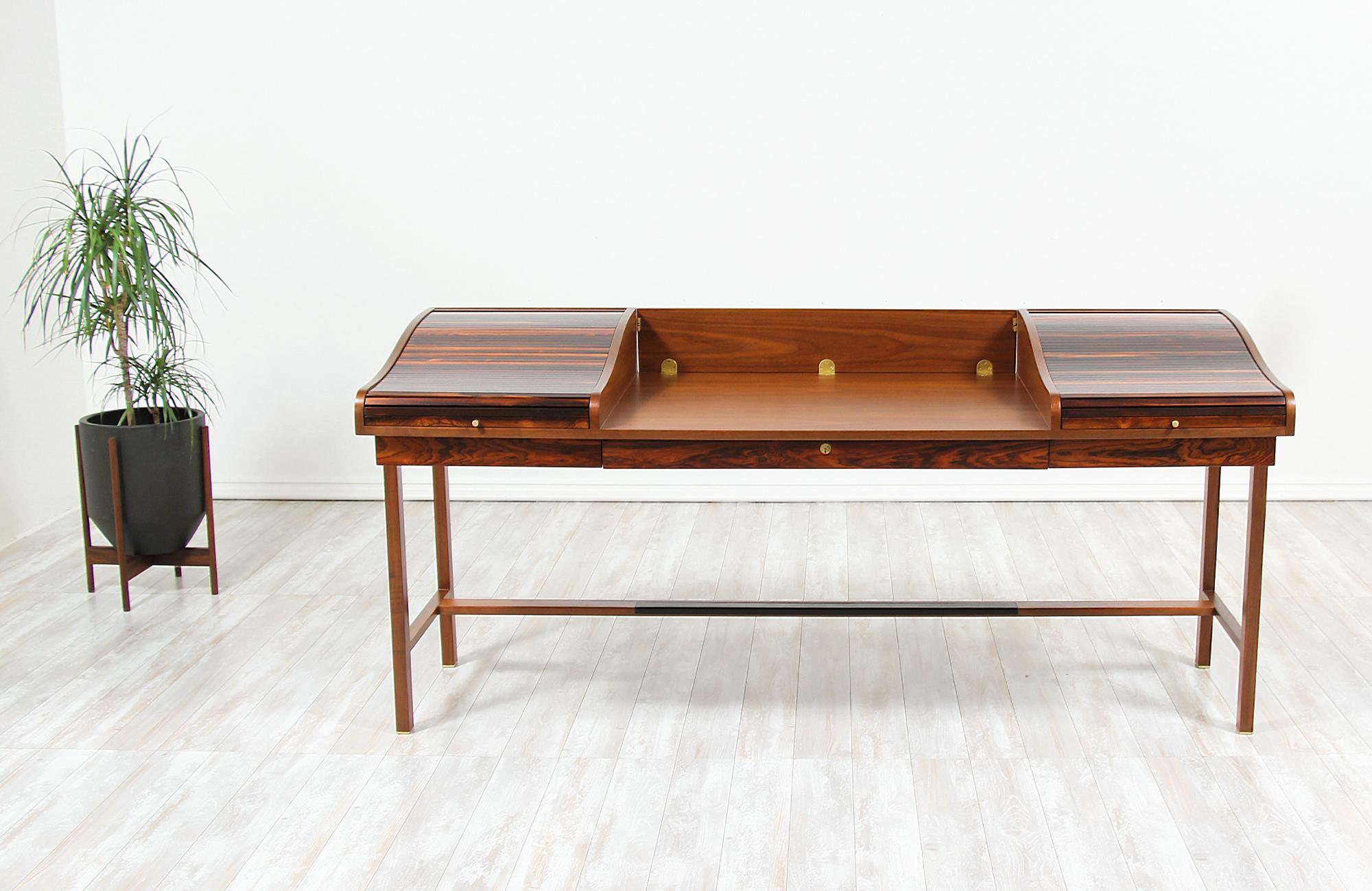 Elegant desk designed by Edward J. Wormley for Dunbar in the United States in 1957. This fabulous model #452 modern executive desk features a solid walnut wood frame and writing surface with a hinged panel at the back that drops, allowing it to