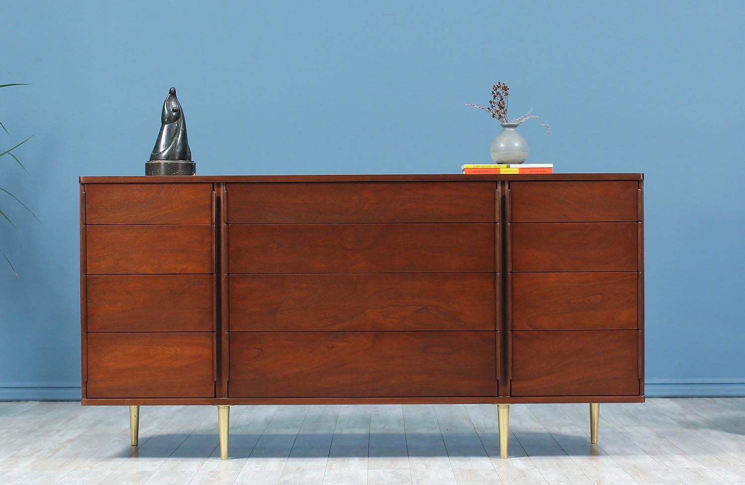 Beautiful dresser designed by Edward J. Wormley for Dunbar in the United States circa 1950’s. Featuring twelve spacious drawers that gradually increase in depth. This walnut-stained mahogany wood dresser features laminated bentwood pulls along the