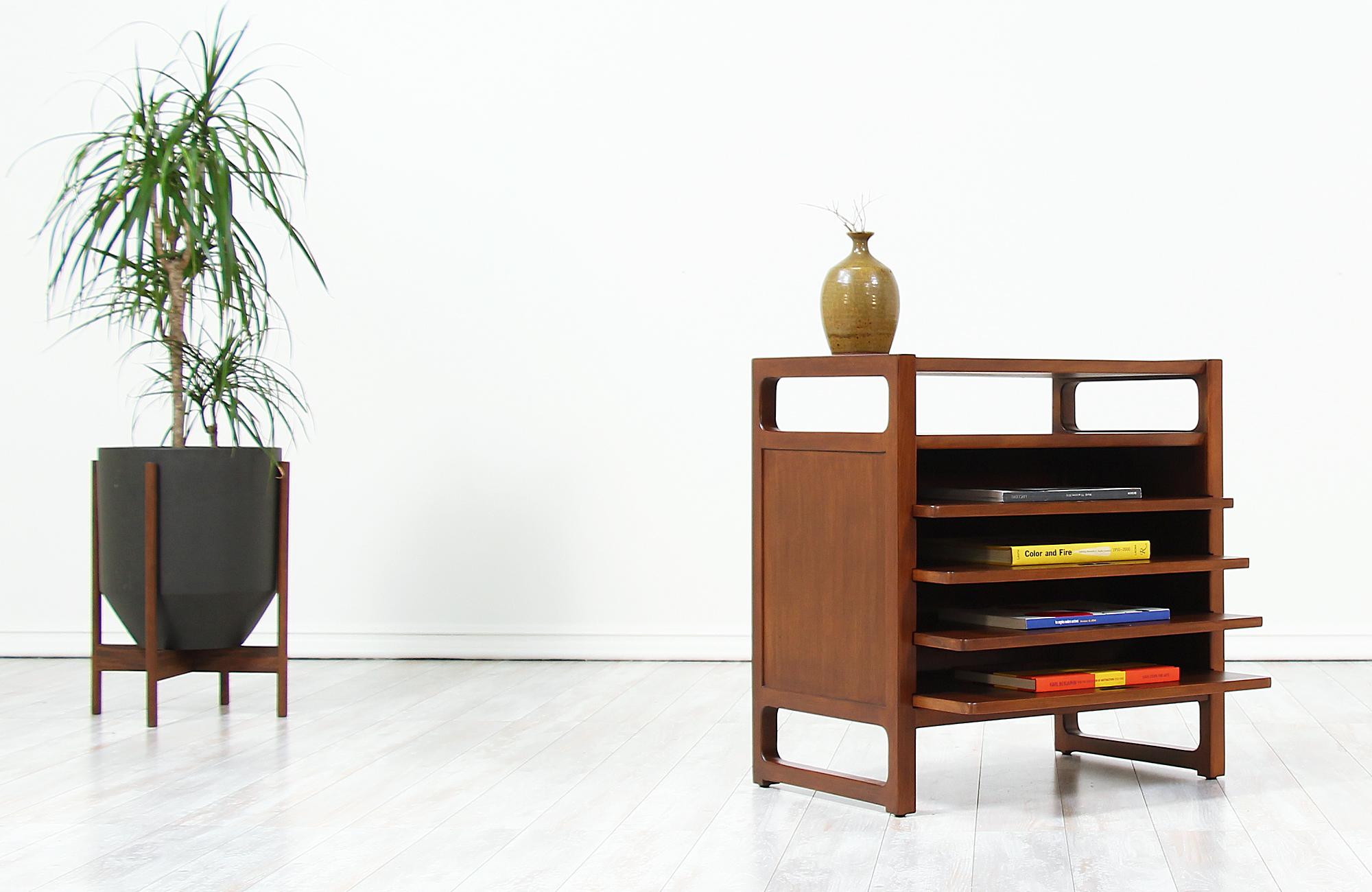Gorgeous magazine table designed by Edward J. Wormley for Drexel’s “Precedent” line in the United States circa 1940s. This unique table features a solid walnut-stained beech wood frame with four sliding shelves that slide smoothly for optimal