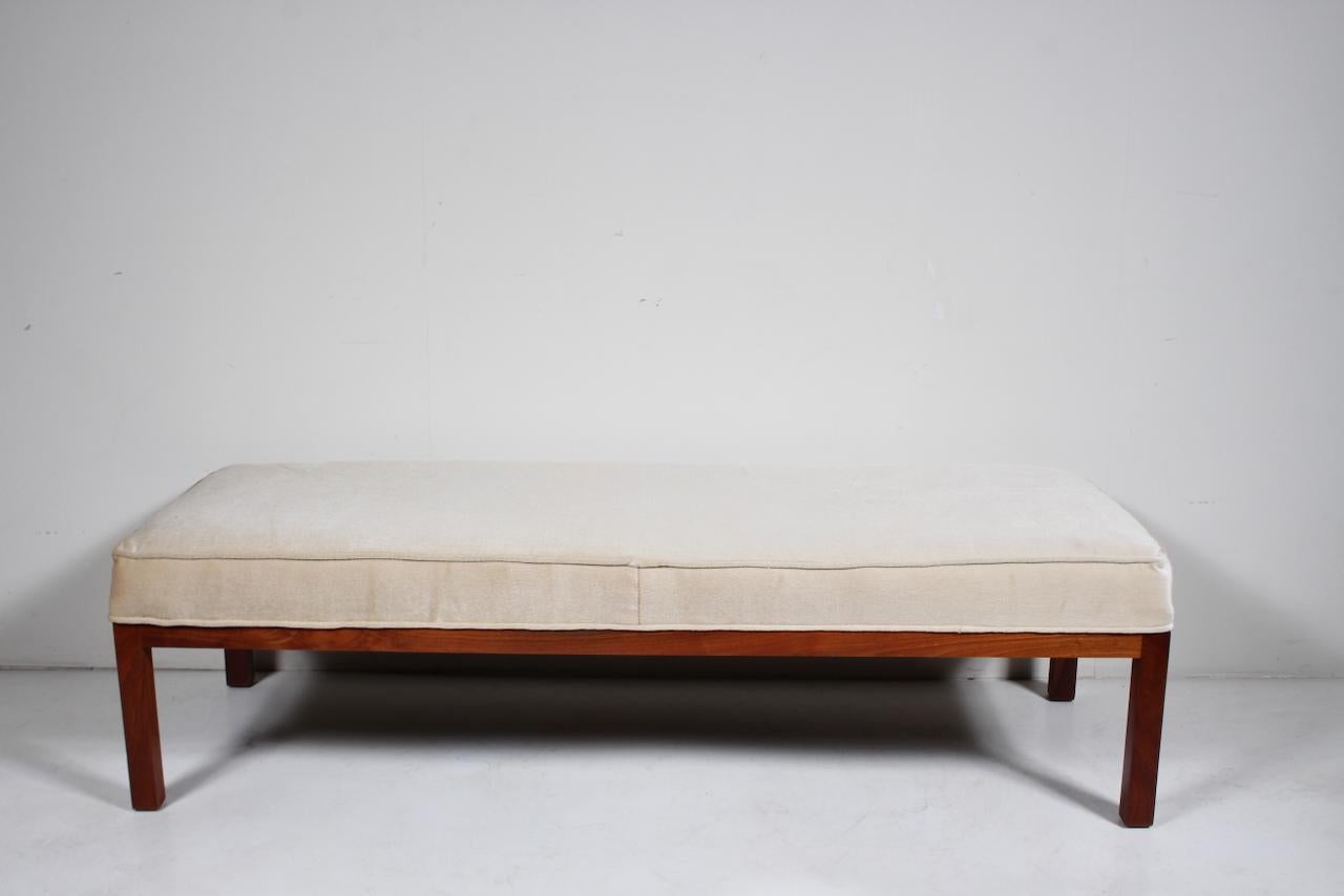 Panchina in noce imbottita di Edward Axel Roffman per B. Altman and Company. Caratterizzata da una forma rettangolare pulita, equilibrata, rinforzata e robusta in stile Parsons, realizzata in massello di noce e con un cuscino singolo rivestito